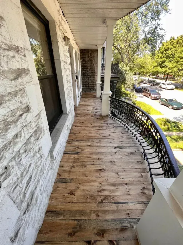 Un escalier menant à une maison avec une rampe en fer forgé.