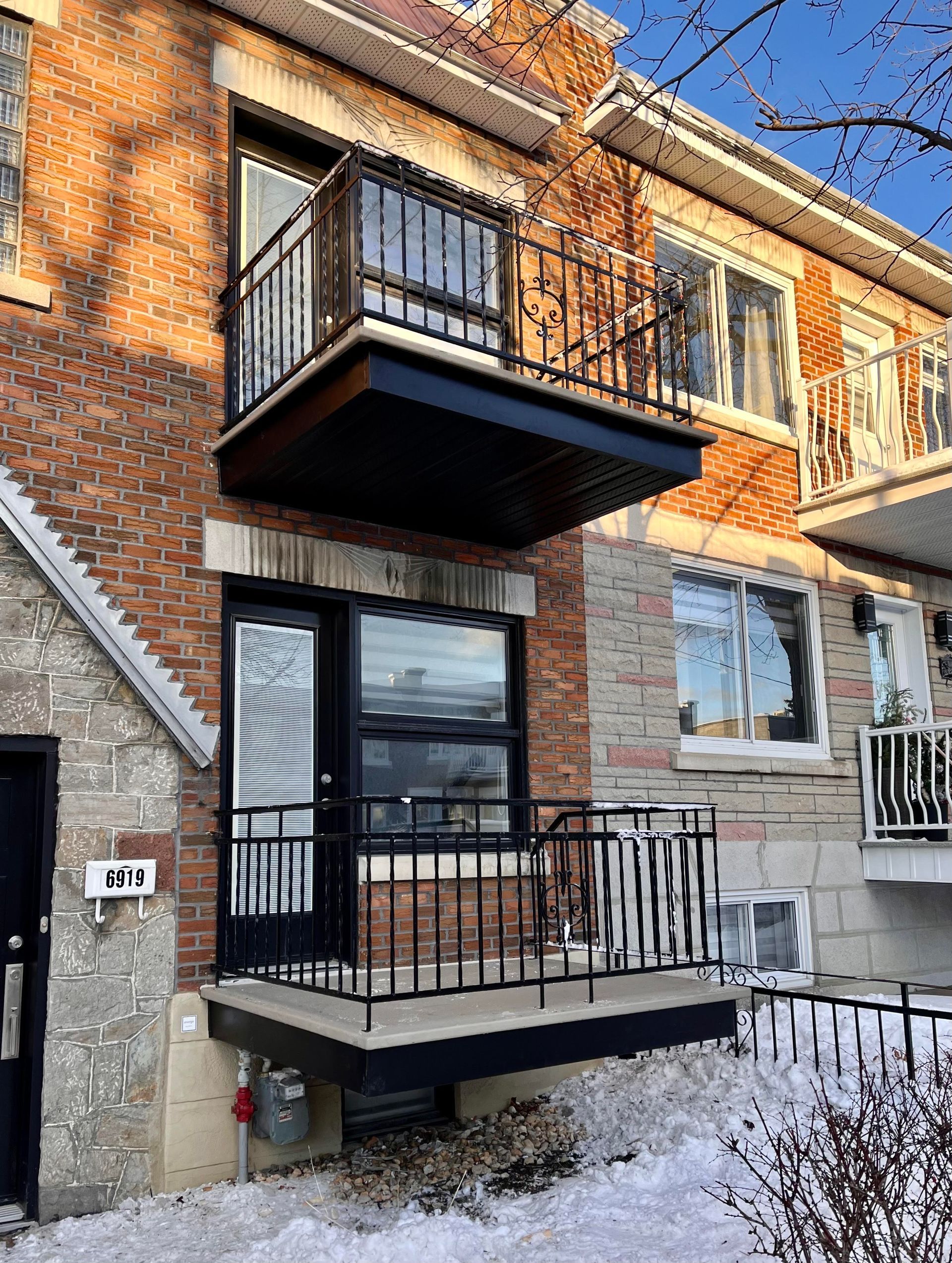 Un bâtiment en briques avec un balcon et une porte.