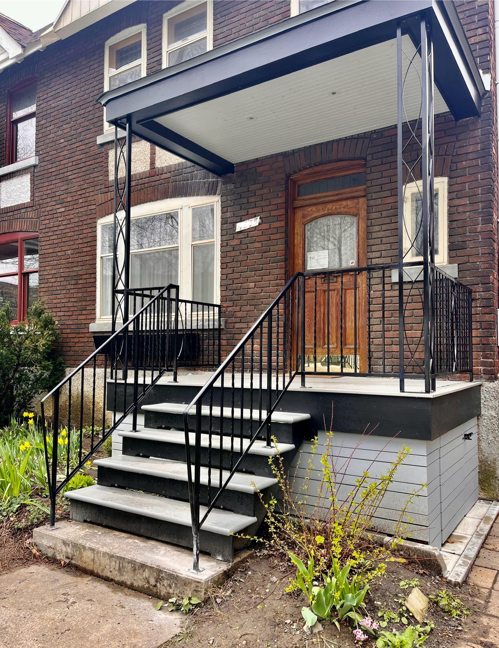 Une maison en brique avec un porche et des escaliers