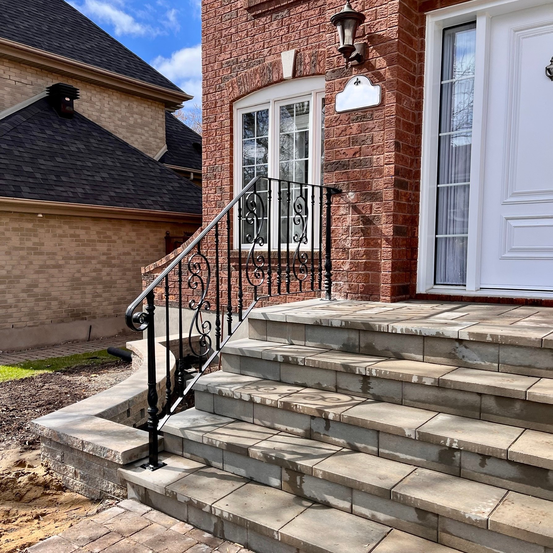 Une maison en brique avec des escaliers menant à la porte d'entrée