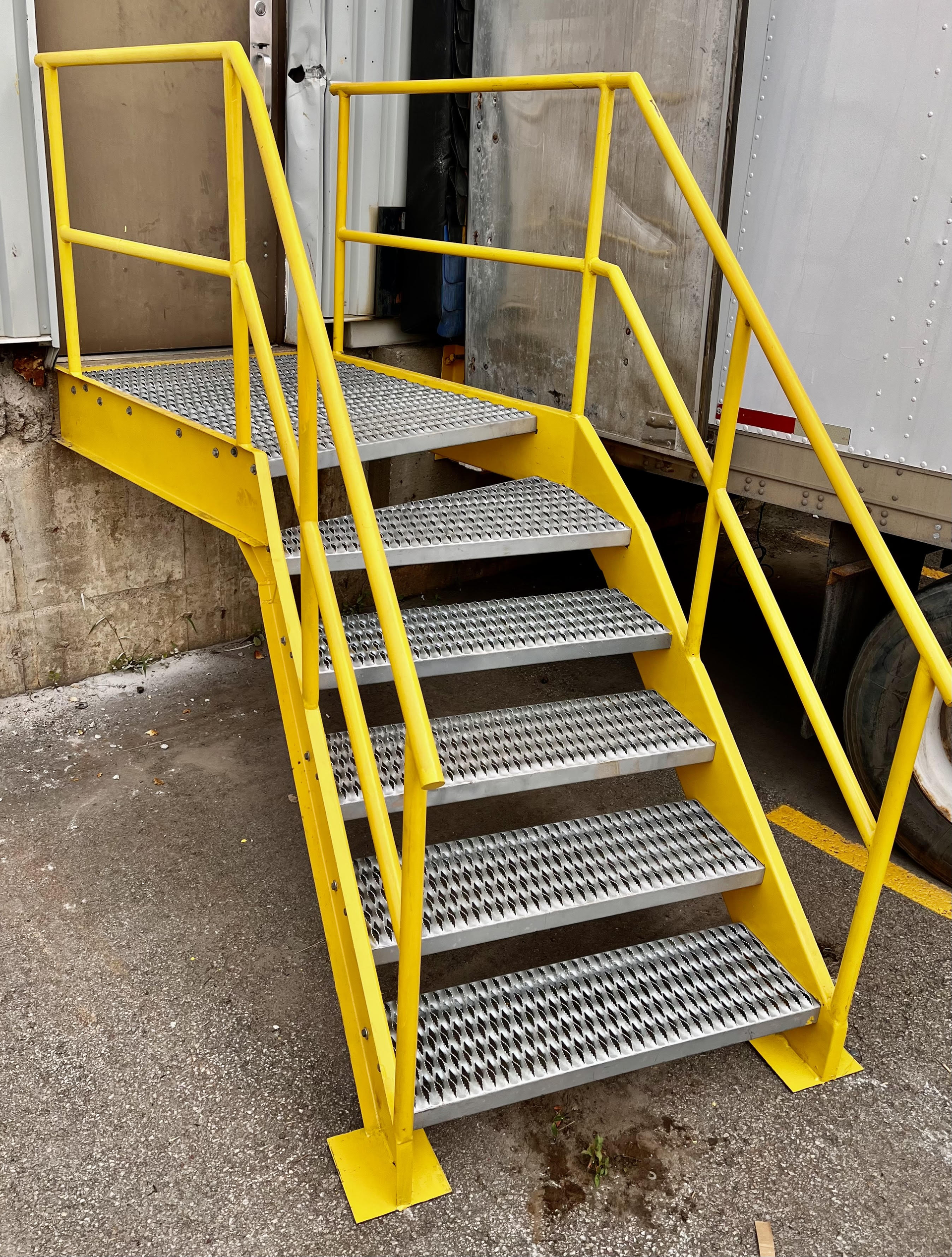 Un escalier en métal avec une rampe jaune