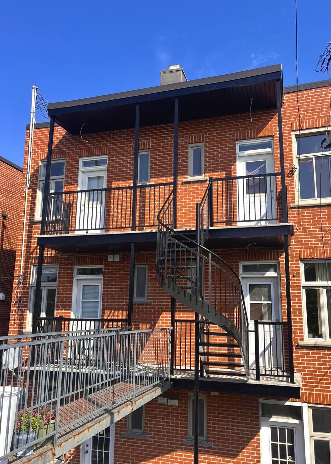 Un bâtiment en briques avec un escalier de secours sur le côté.