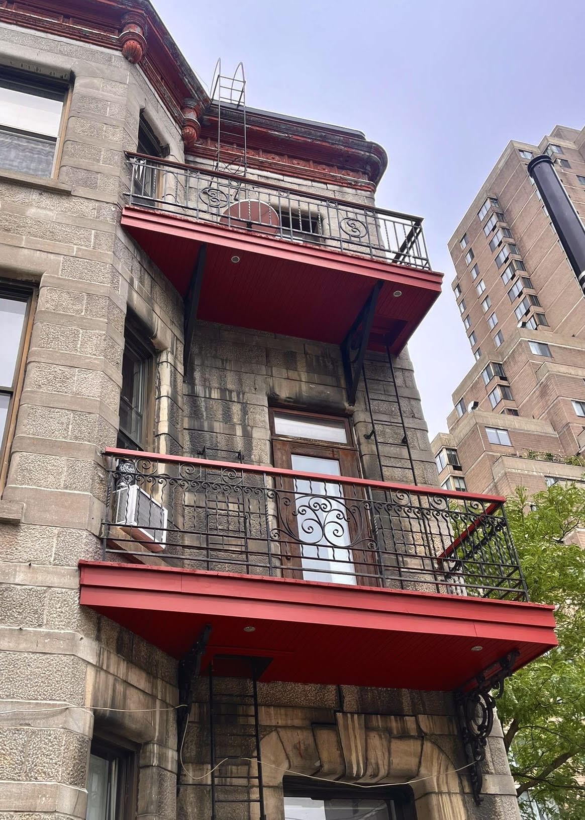 Un bâtiment en briques avec un balcon rouge au-dessus