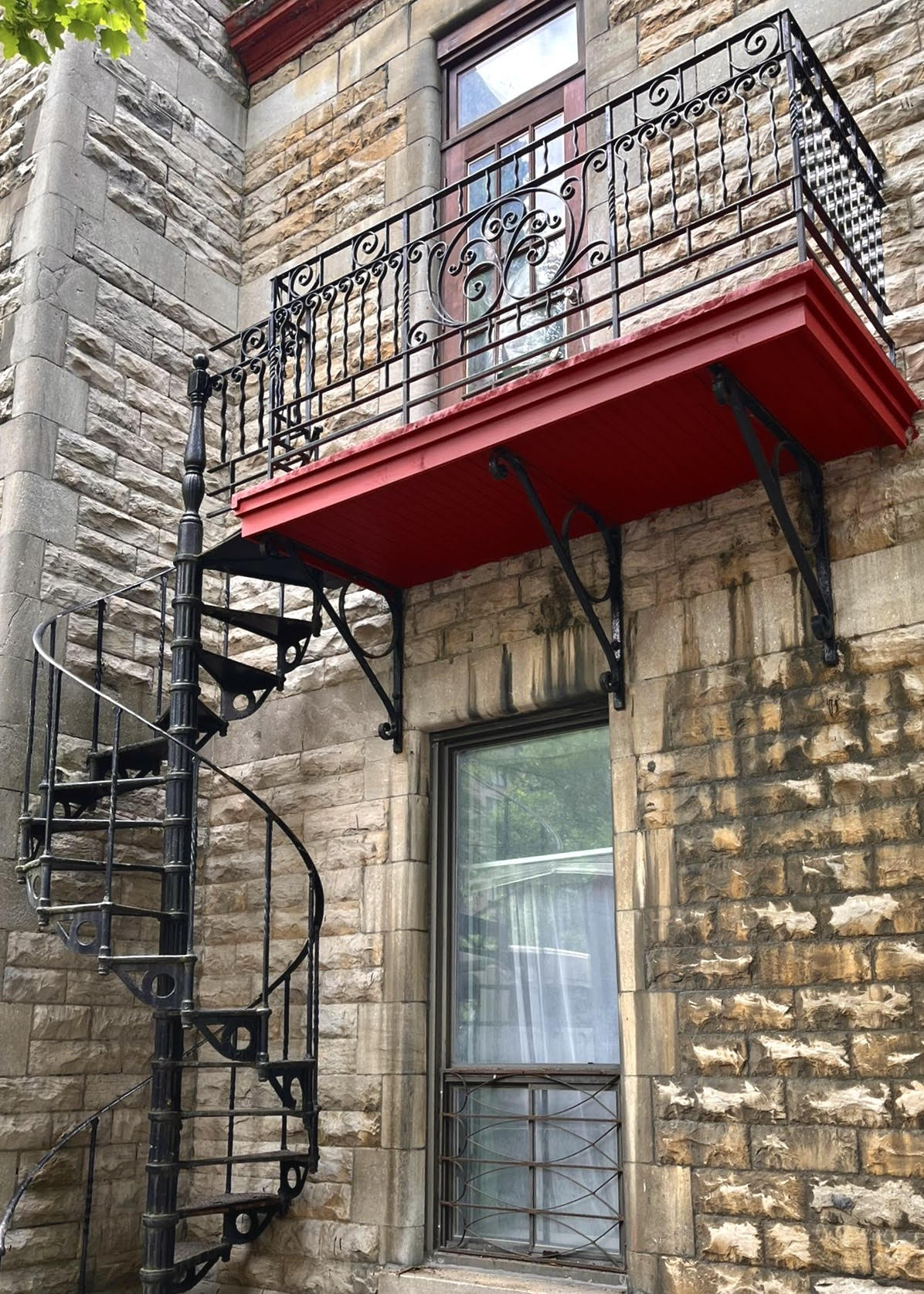 Un escalier en colimaçon est fixé sur le côté d'un bâtiment en briques.