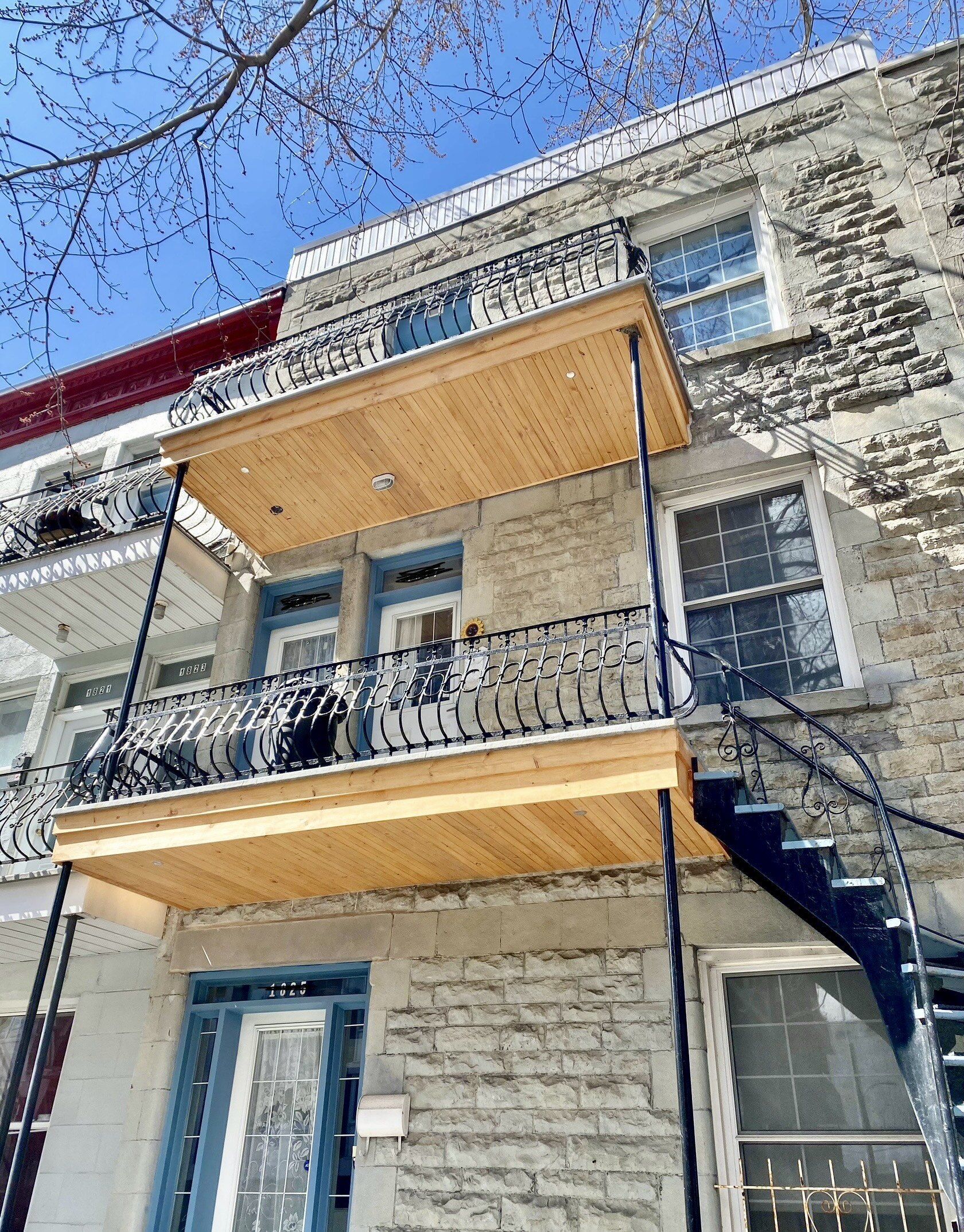 Un grand bâtiment en briques avec un balcon et des escaliers en bois.