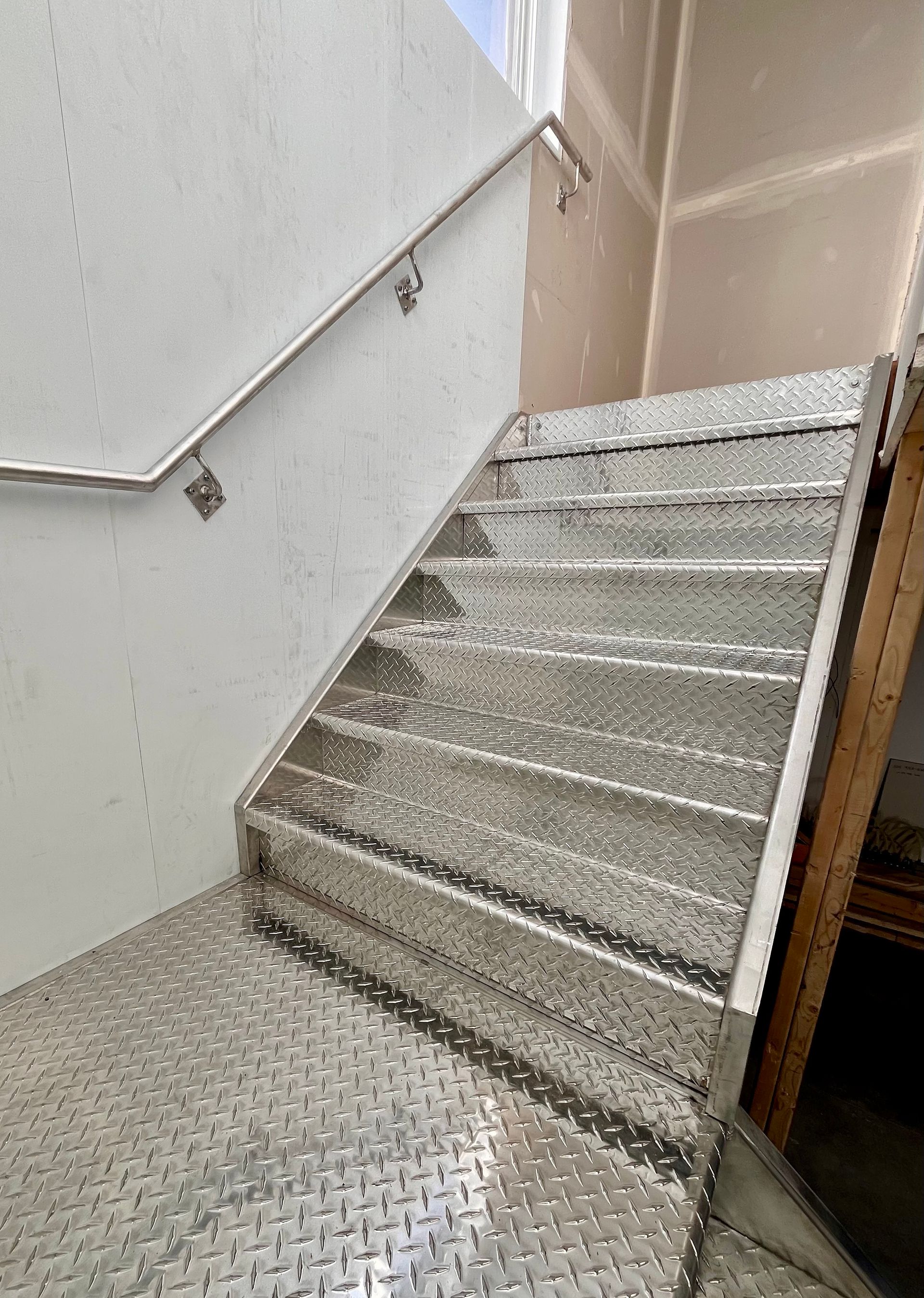 Un escalier avec une rampe en acier inoxydable dans un immeuble.