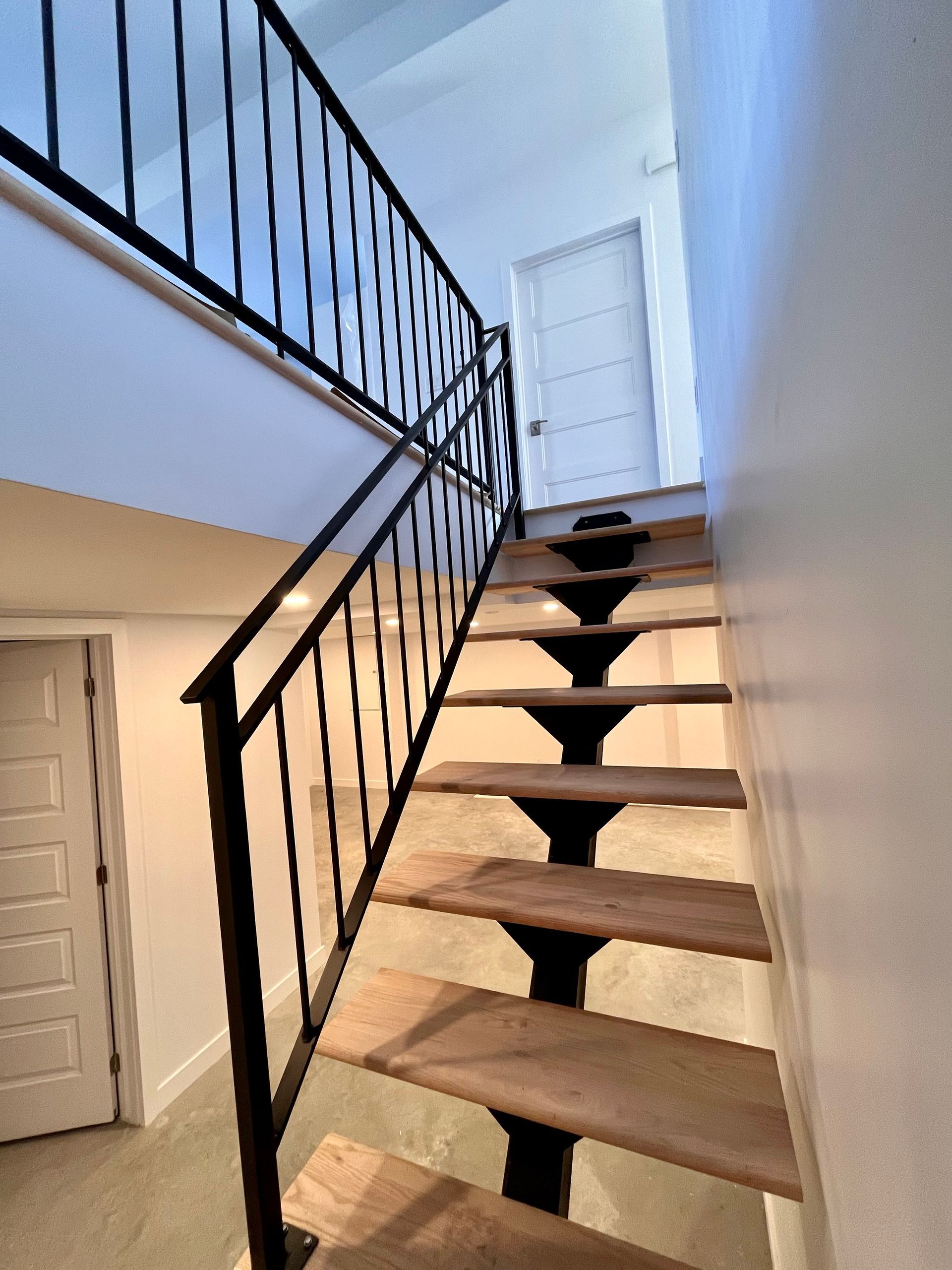 Un escalier avec des marches en bois et une rampe en métal