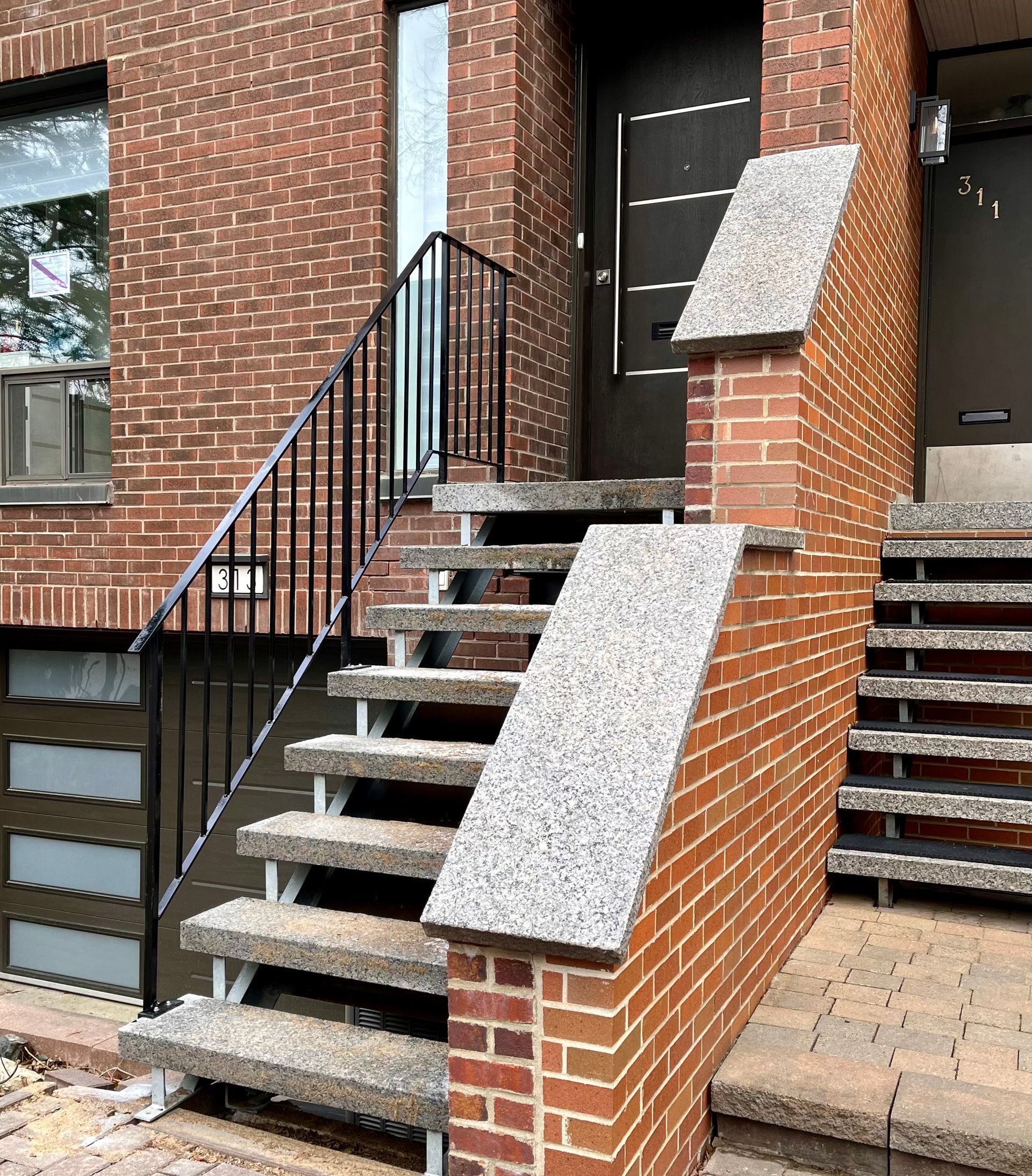 Un bâtiment en brique avec des escaliers menant à la porte d'entrée