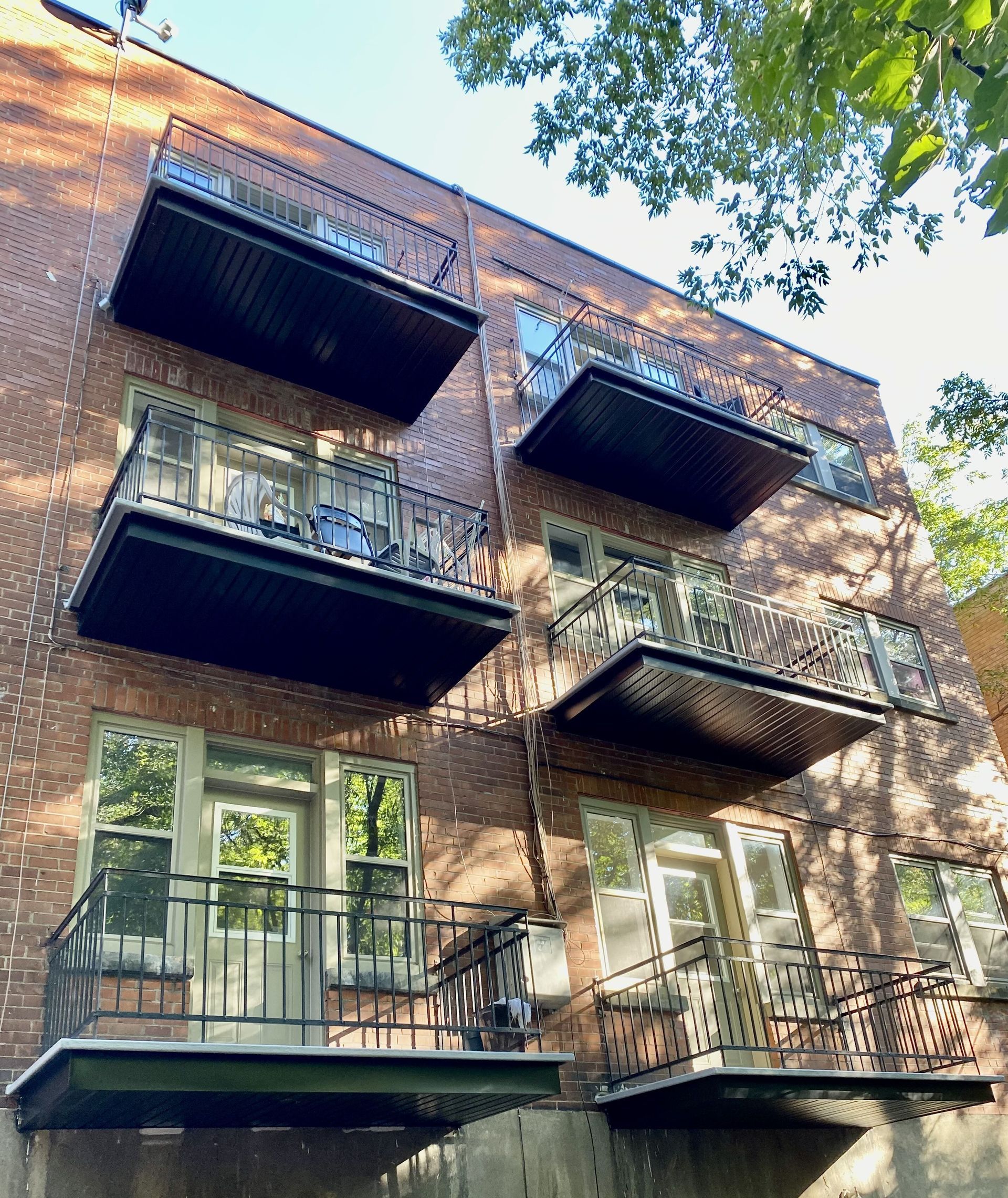 Un grand bâtiment en briques avec beaucoup de balcons et de fenêtres.