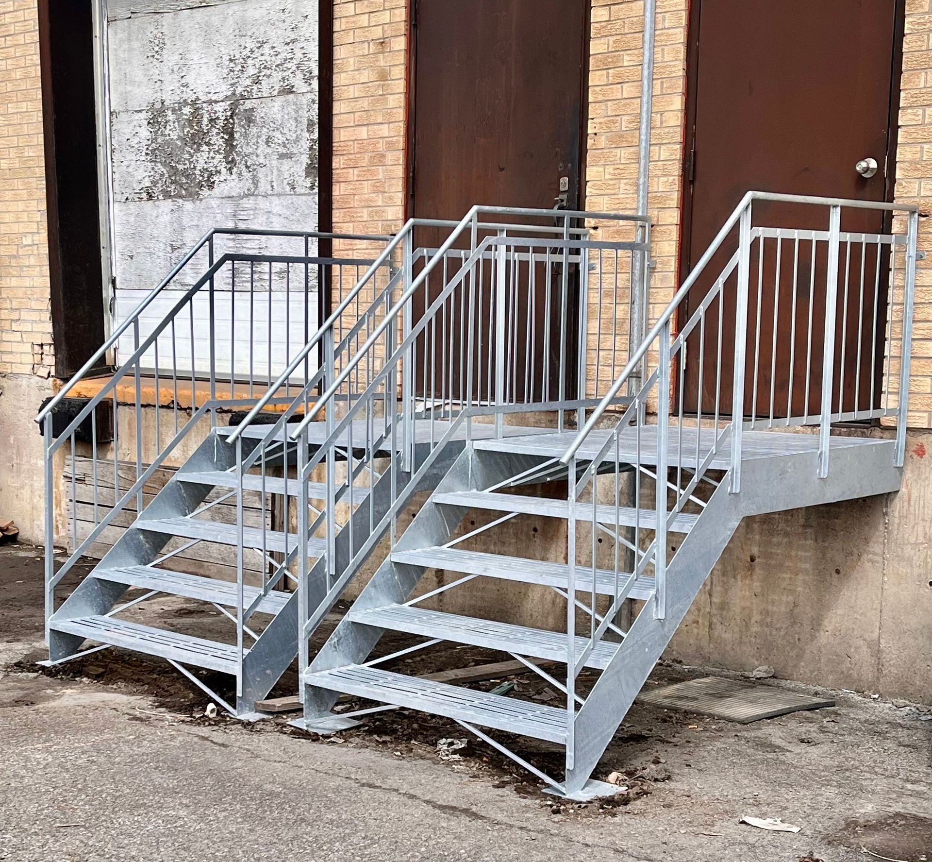 Un escalier métallique menant à un bâtiment en brique.
