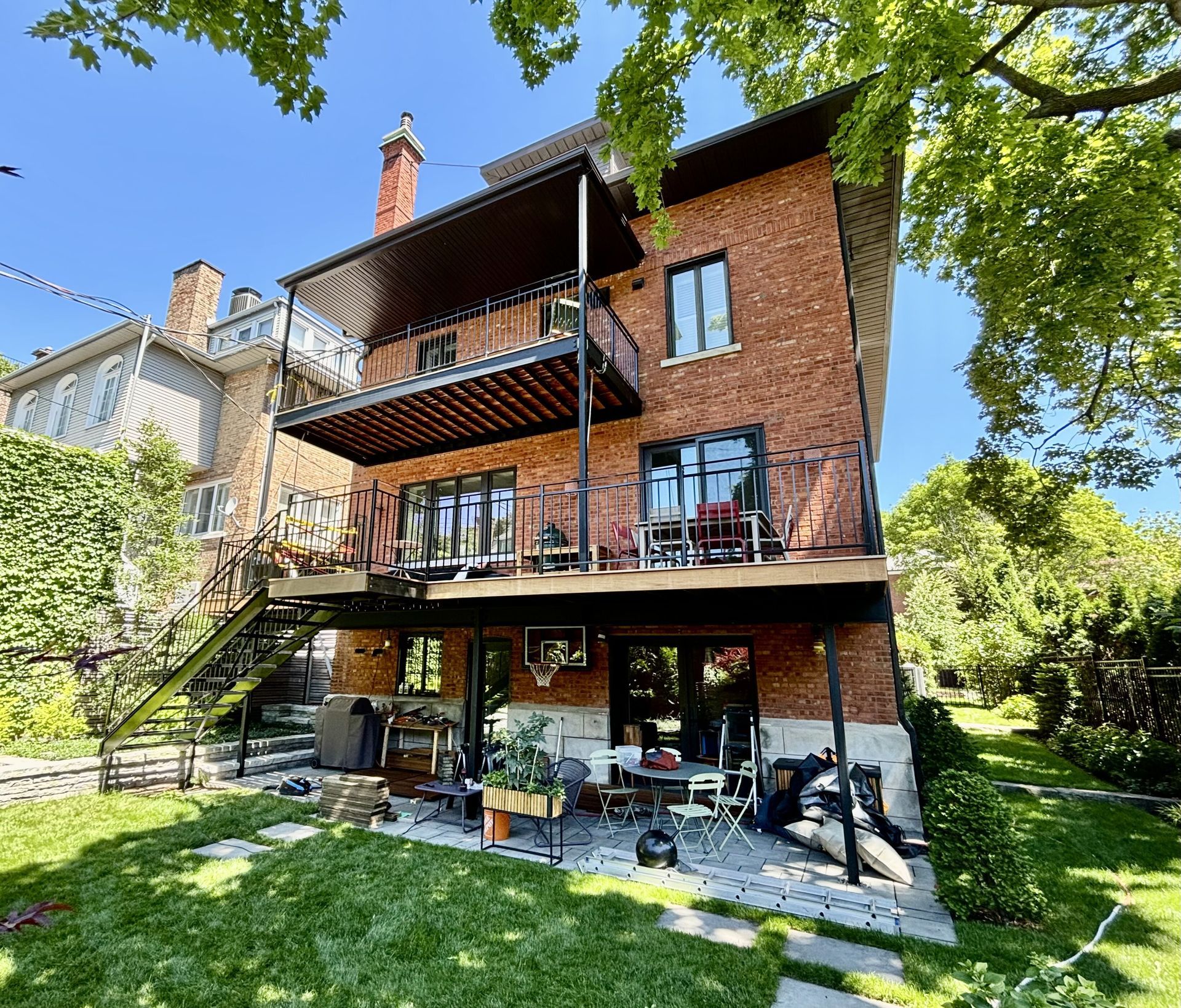 Une grande maison en brique avec balcon et escaliers