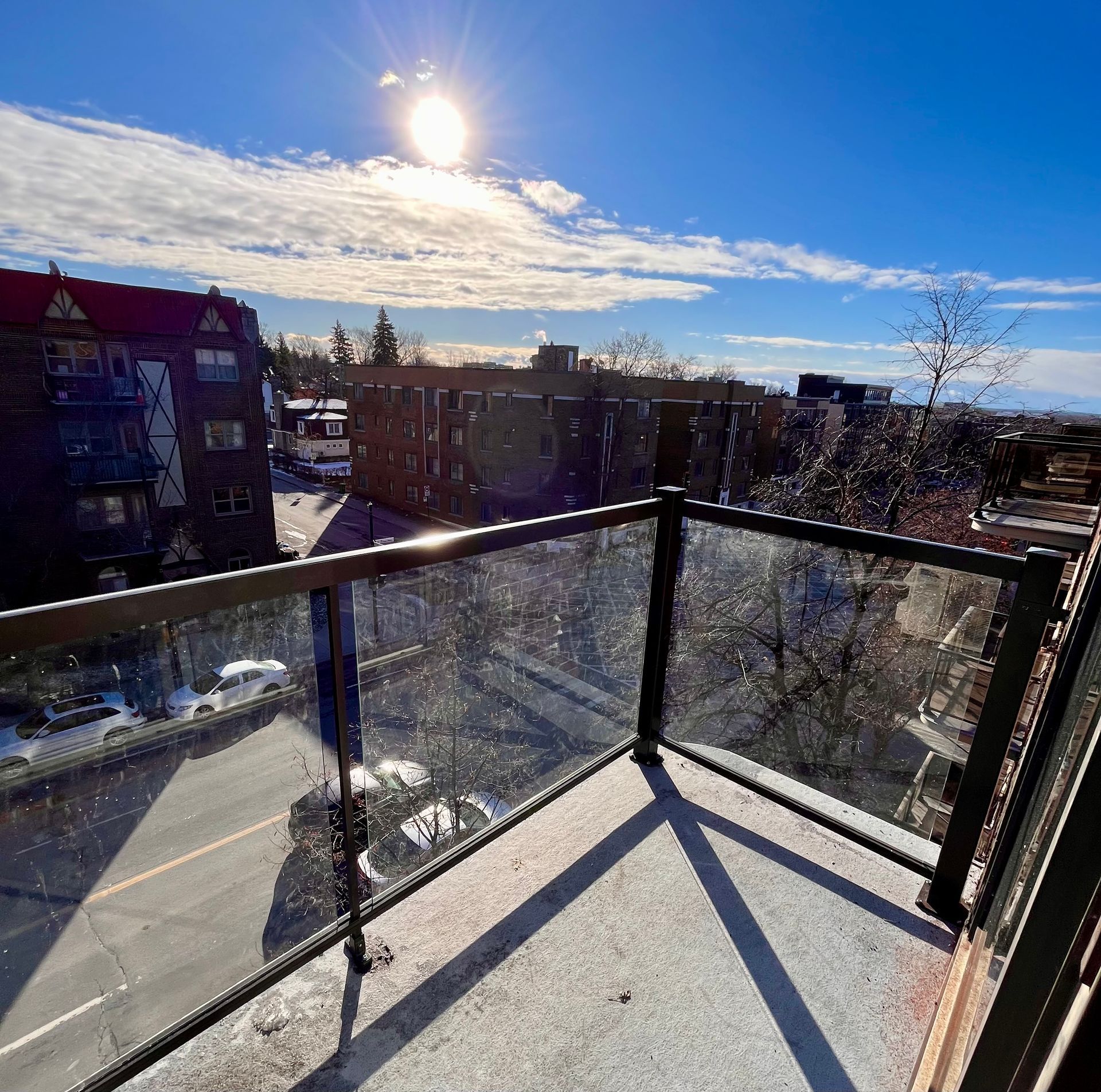Une vue sur une ville depuis un balcon avec une balustrade en verre