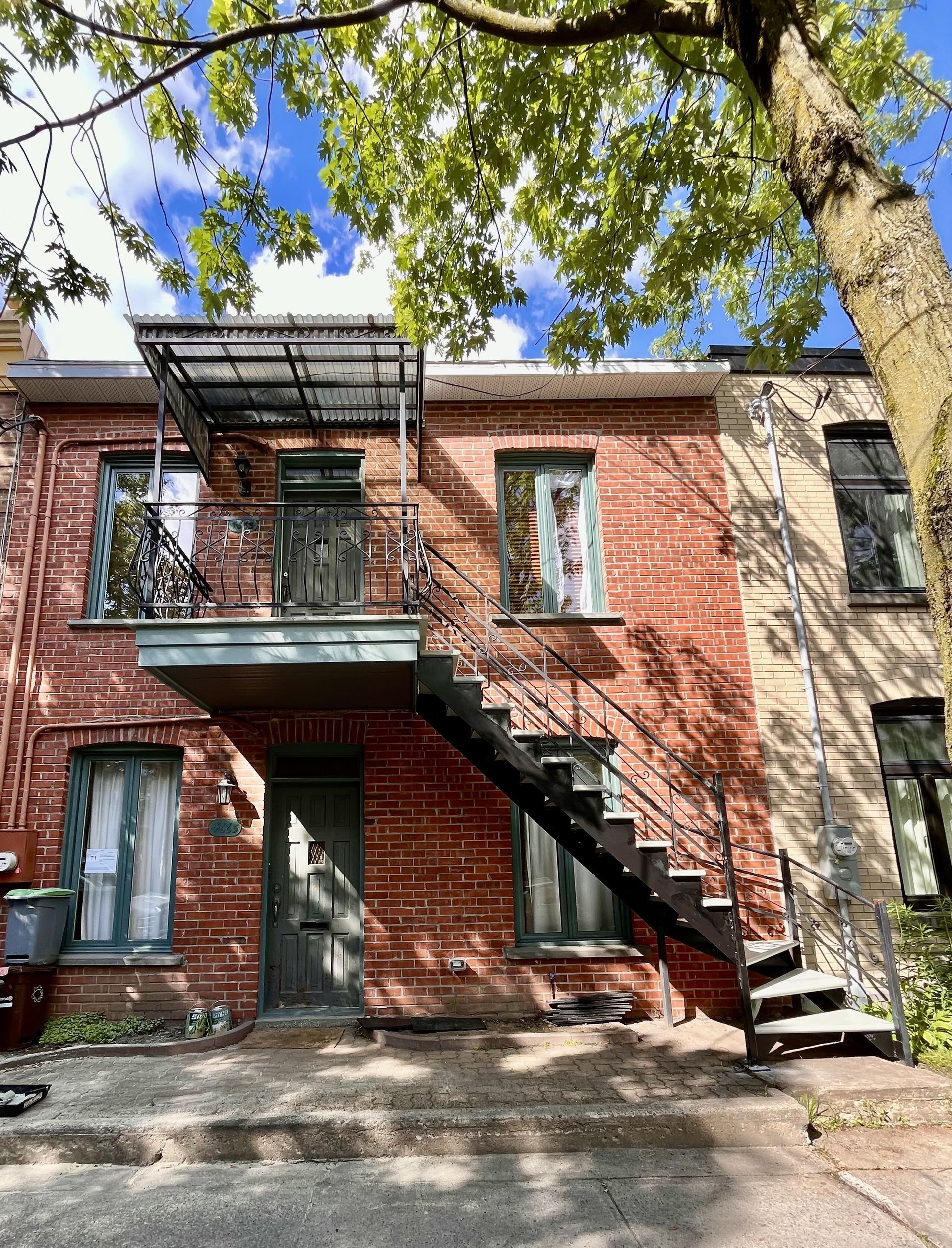Un immeuble en brique avec des escaliers menant au deuxième étage.