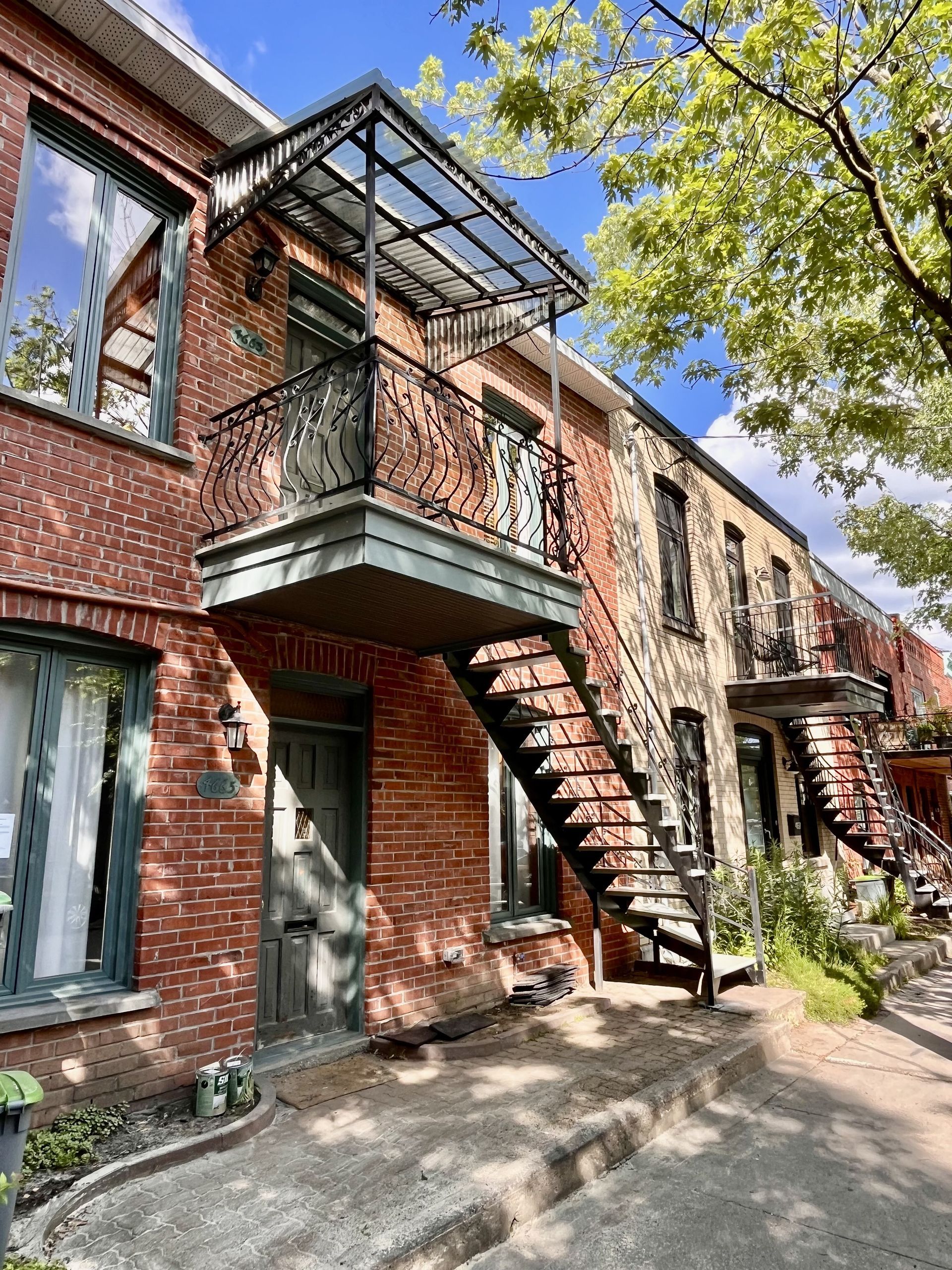 Un immeuble en brique avec des escaliers menant au deuxième étage.