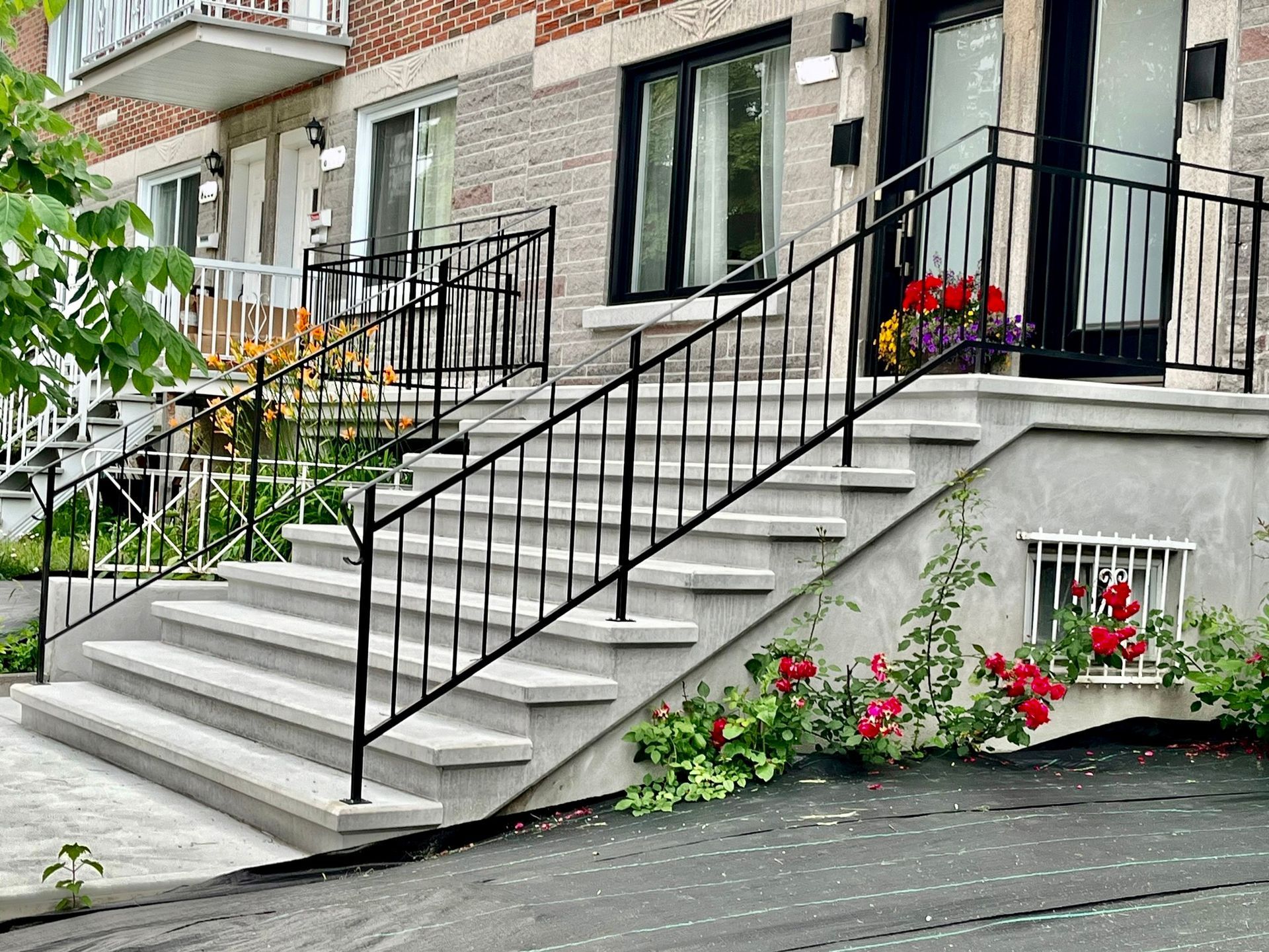 Un escalier menant à un bâtiment avec une rampe en fer forgé.