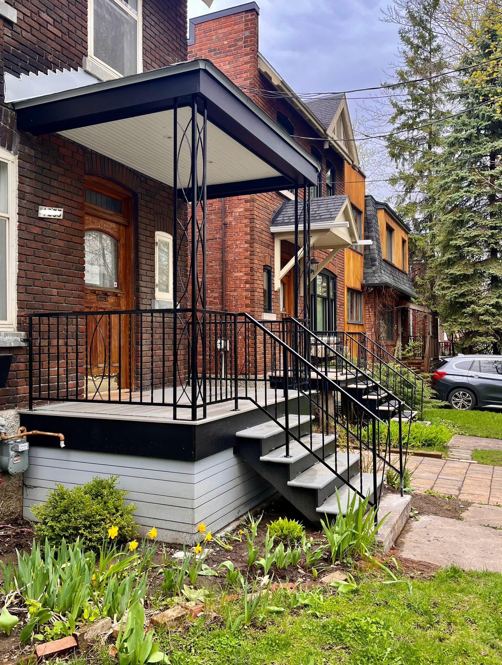 Une maison en brique avec un porche et des escaliers devant.