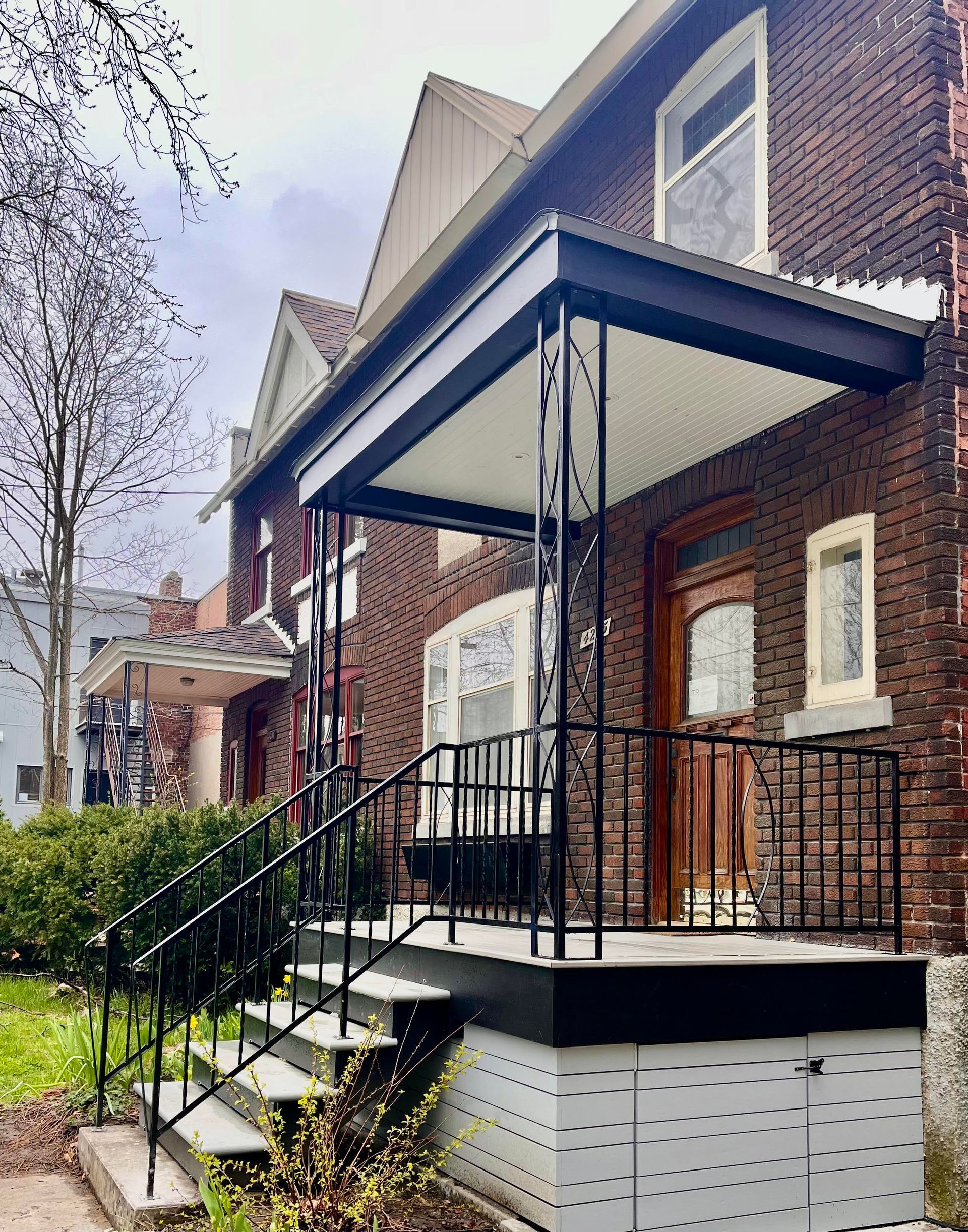 Une maison en brique avec un porche et des escaliers