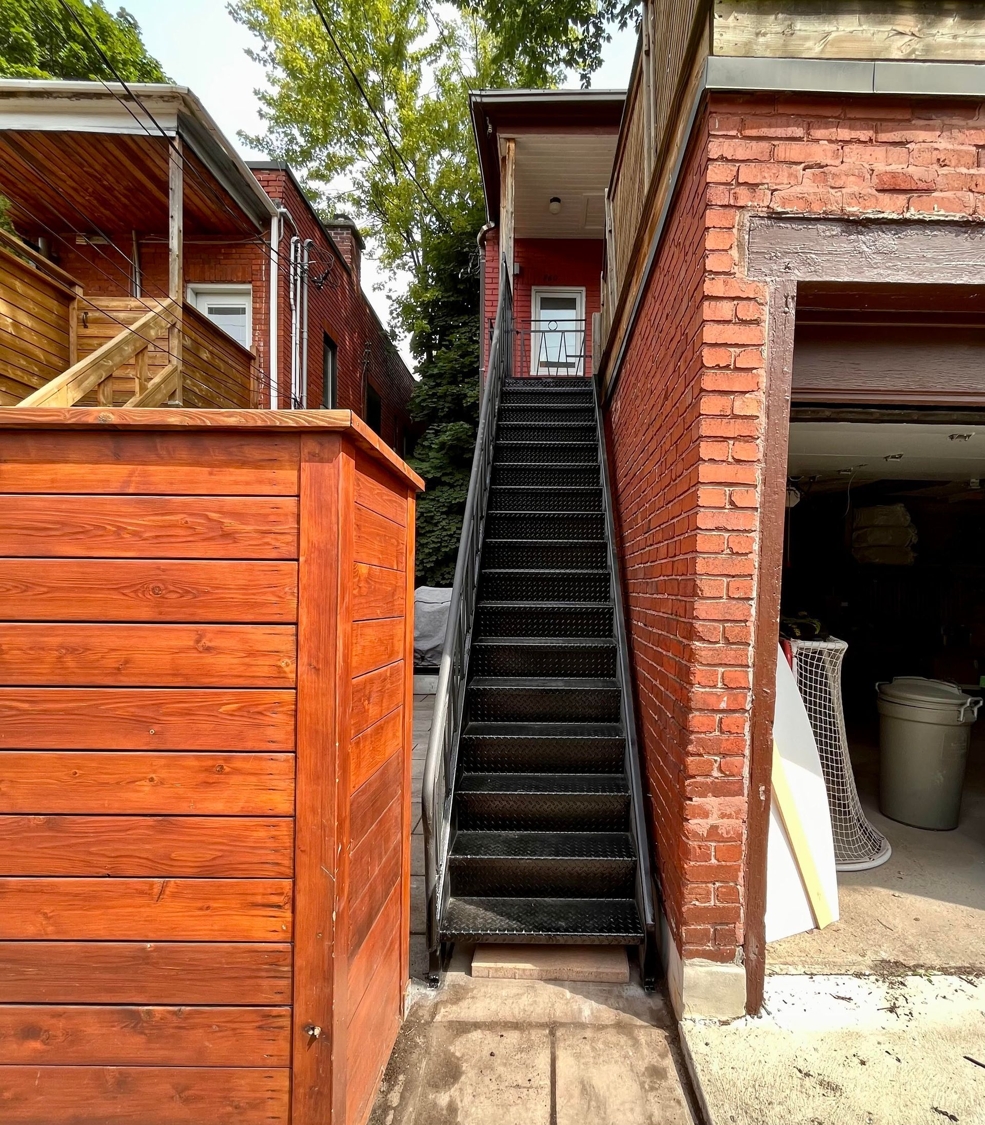 Un escalier menant à un garage à côté d'un bâtiment en brique.
