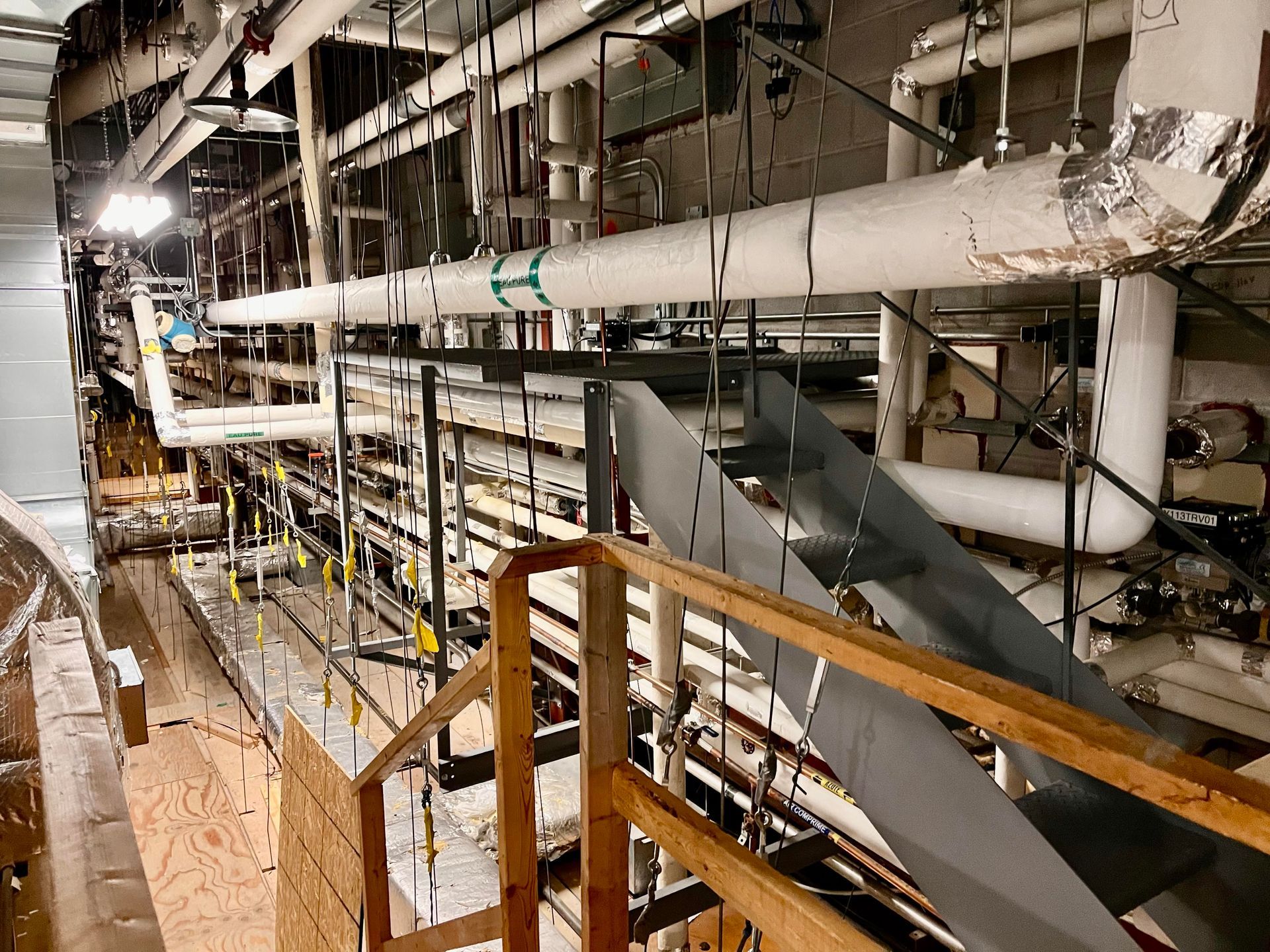 Il y a de nombreux tuyaux suspendus au plafond d'un bâtiment.