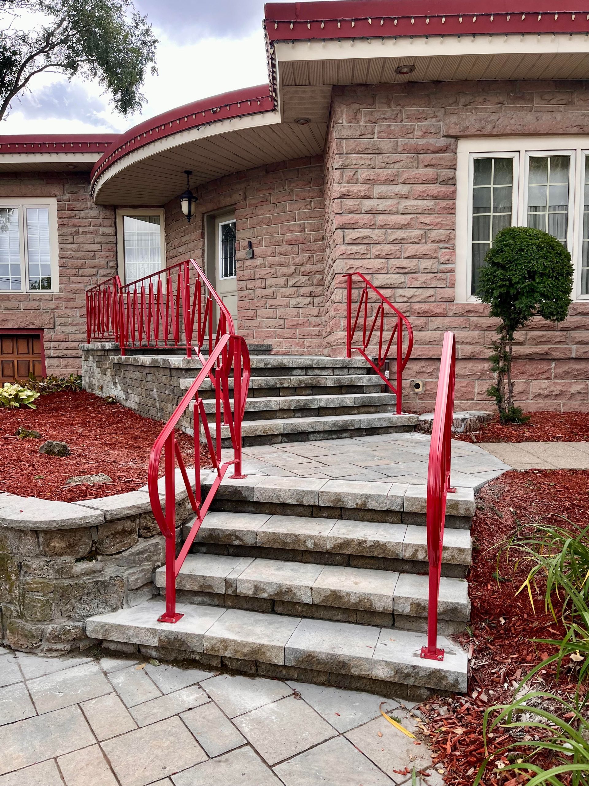 Une maison en briques avec une balustrade et des escaliers rouges