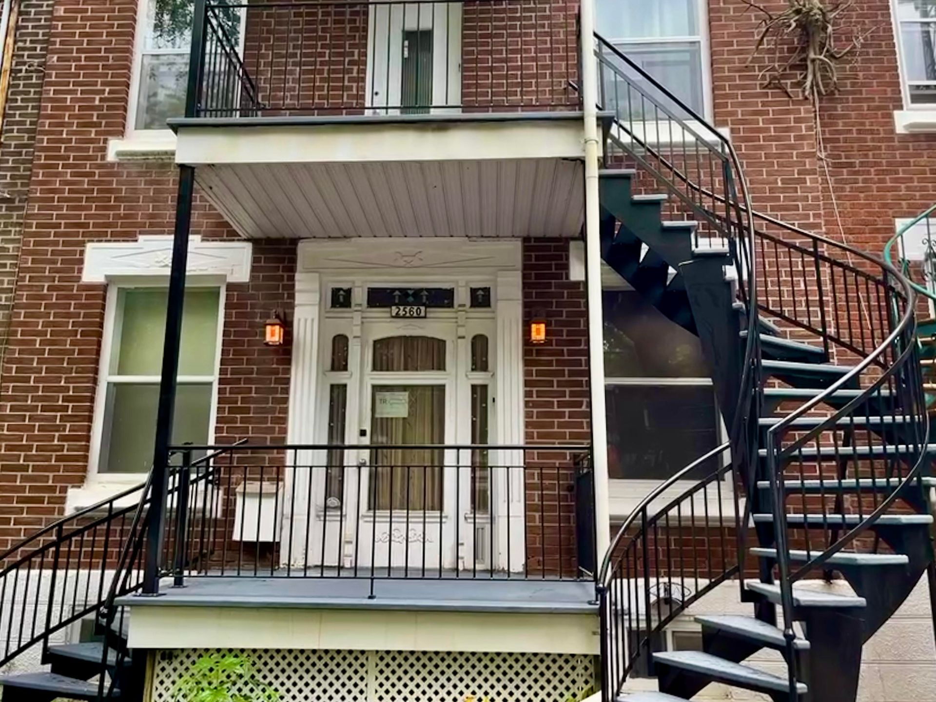 Un bâtiment en brique avec un escalier en colimaçon menant au deuxième étage.