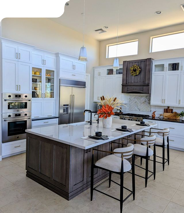 Modern kitchen with white cabinets, dark island, stainless steel appliances, and bar seating.