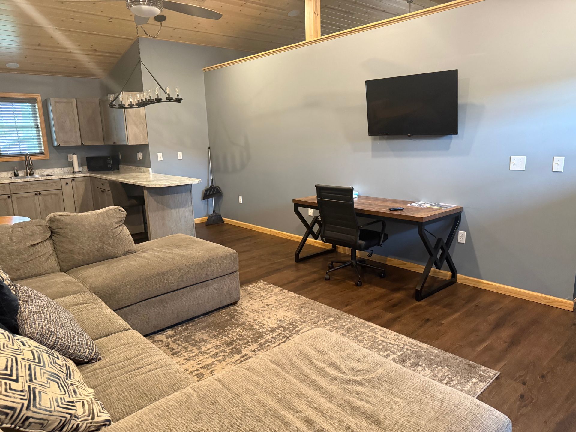 A living room with a couch , desk and television.