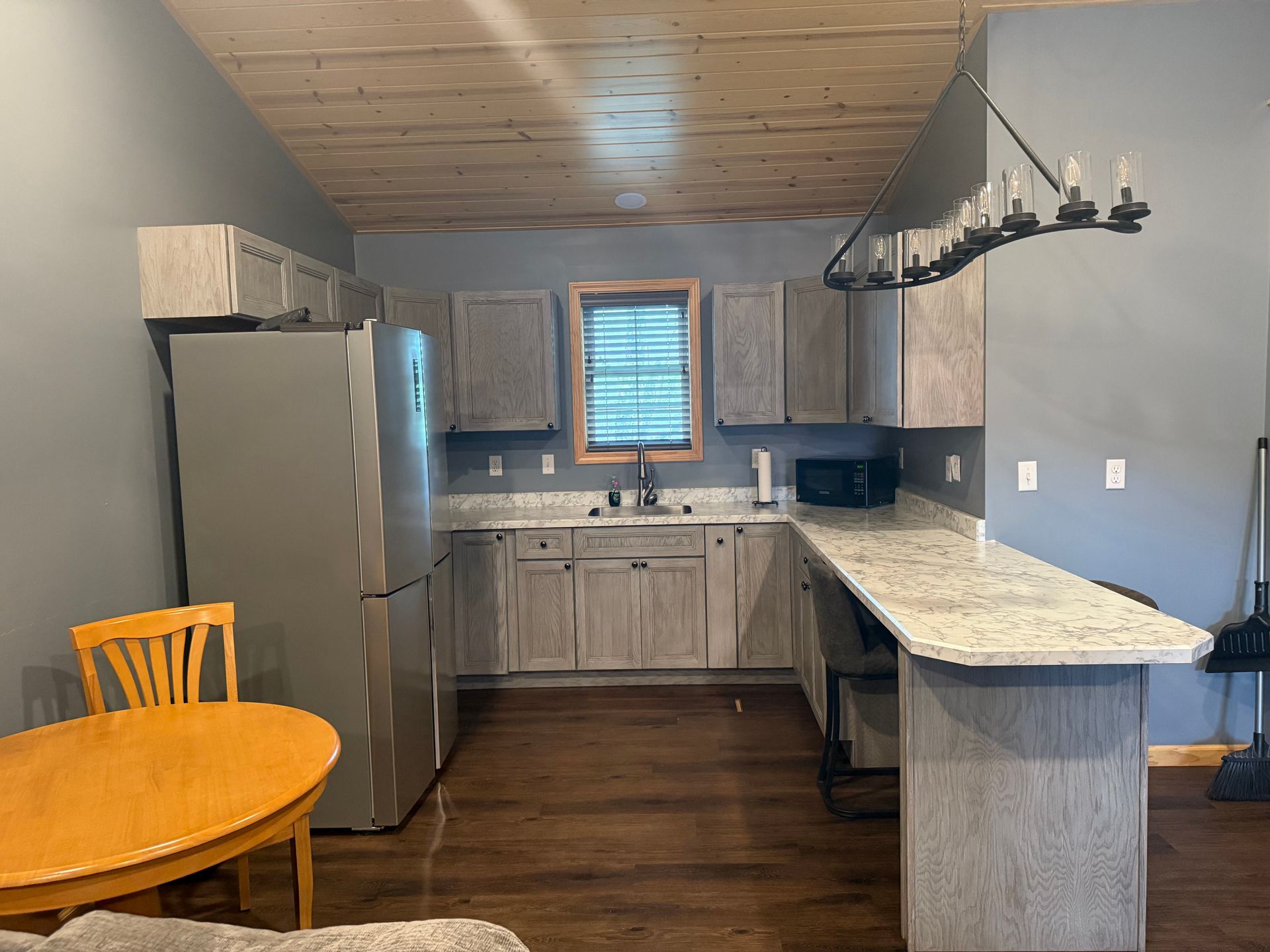 A kitchen with a table and chairs and a refrigerator.