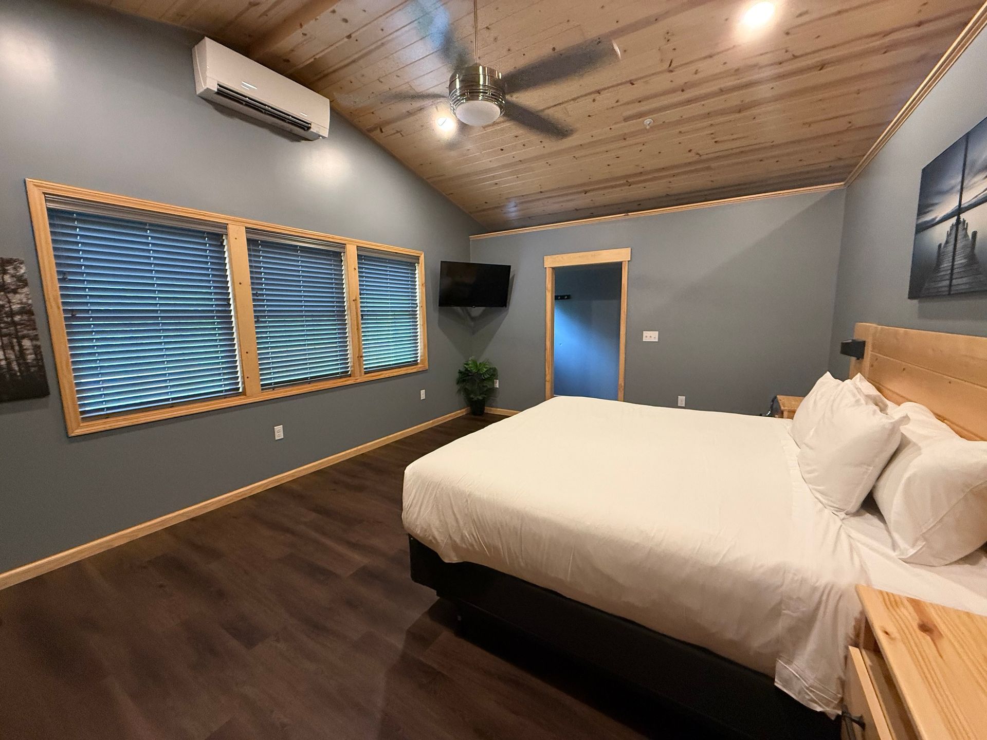A bedroom with a king size bed and a ceiling fan.