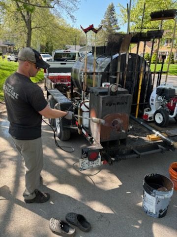 A man is standing next to a trailer with a machine on it.