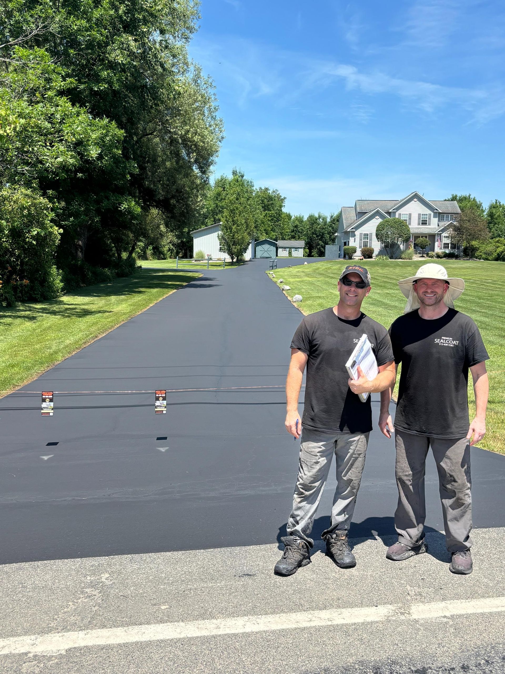 Two men are standing next to each other on the side of a road.