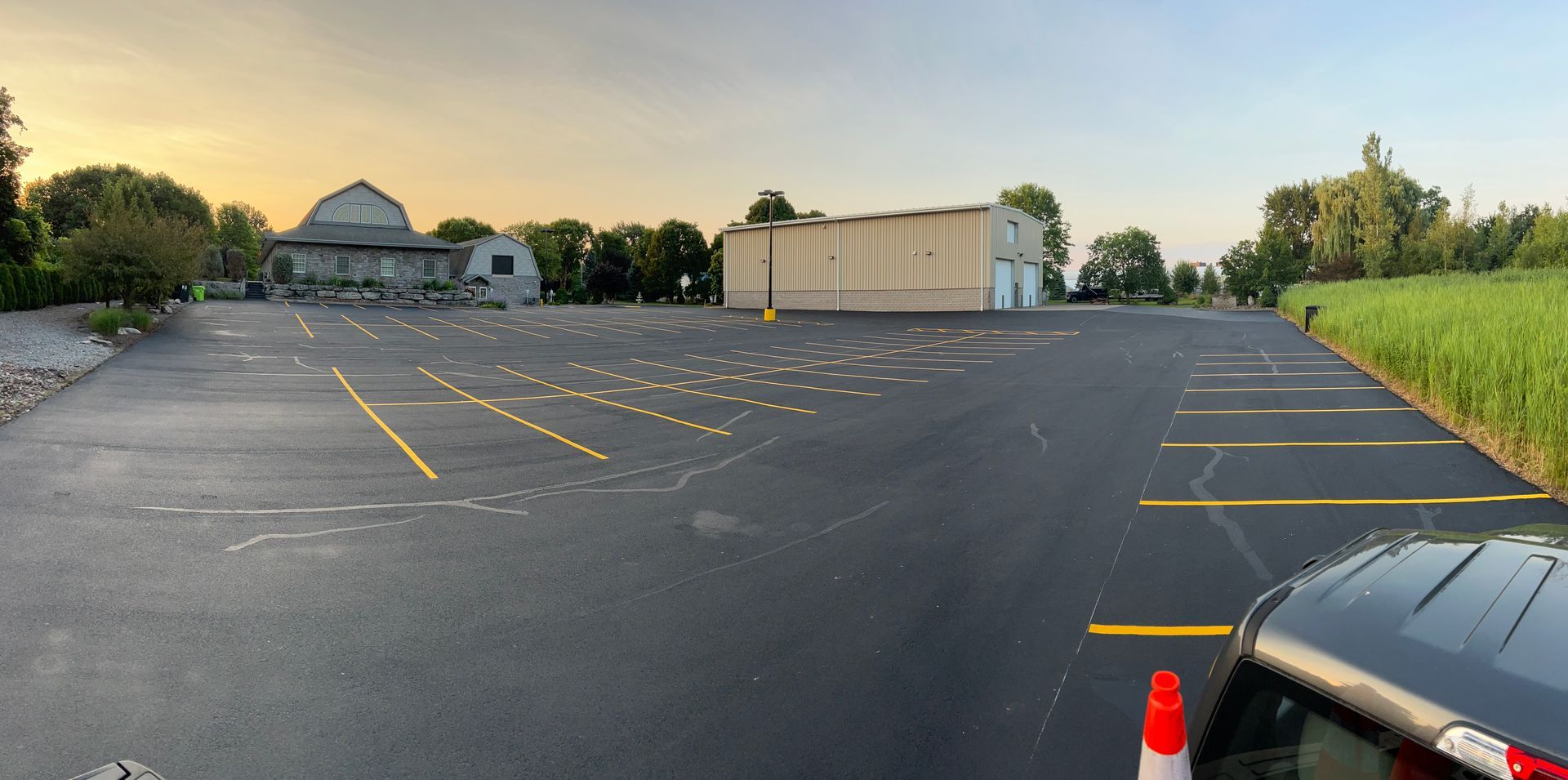 A car is parked in a parking lot with a building in the background.