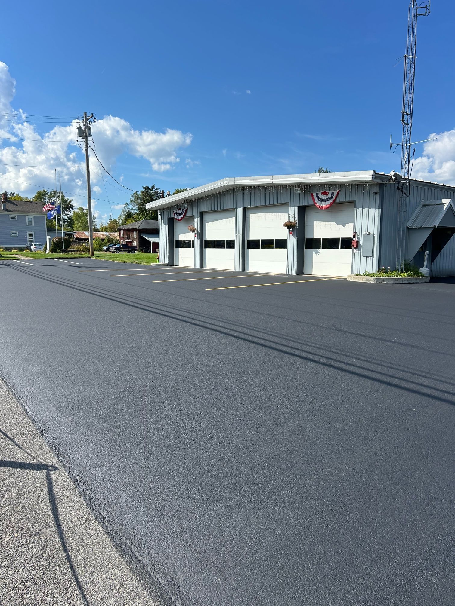 Fire station with three garage doors, blue sky.