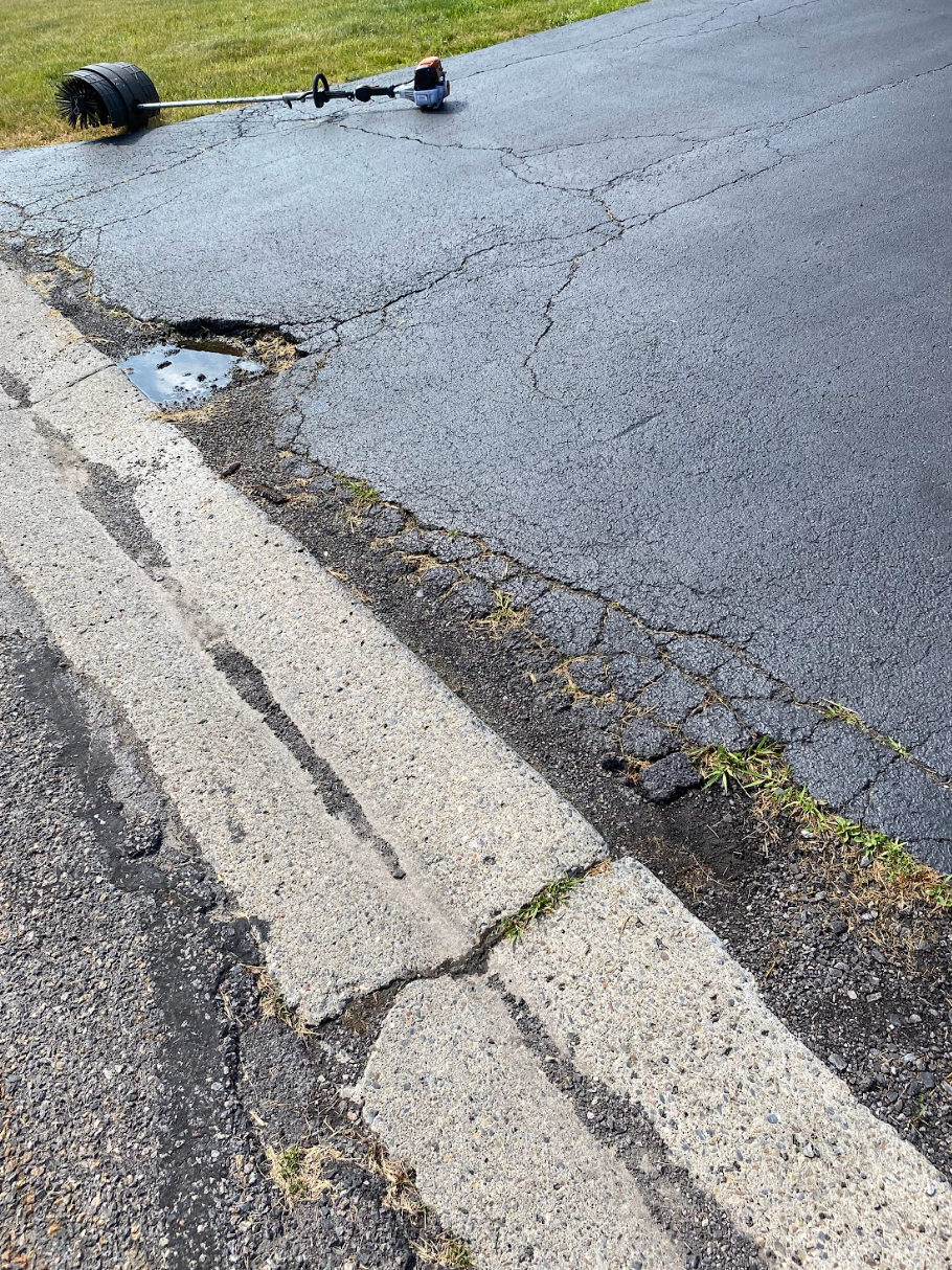 A lawn mower is sitting on the side of a road.