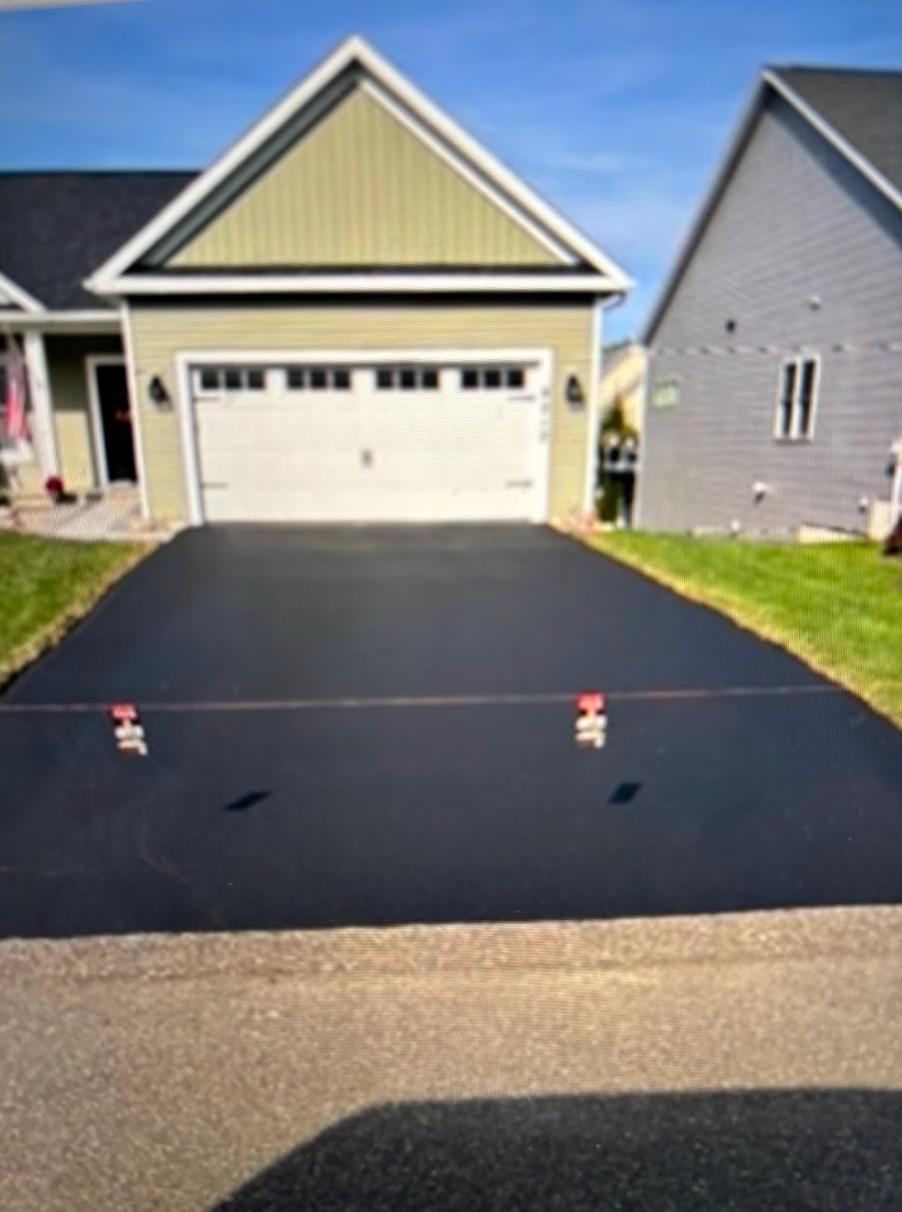 A house with a black driveway and a white garage door