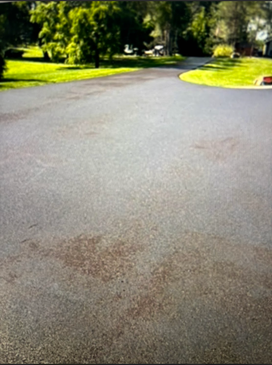 A black asphalt road with trees in the background