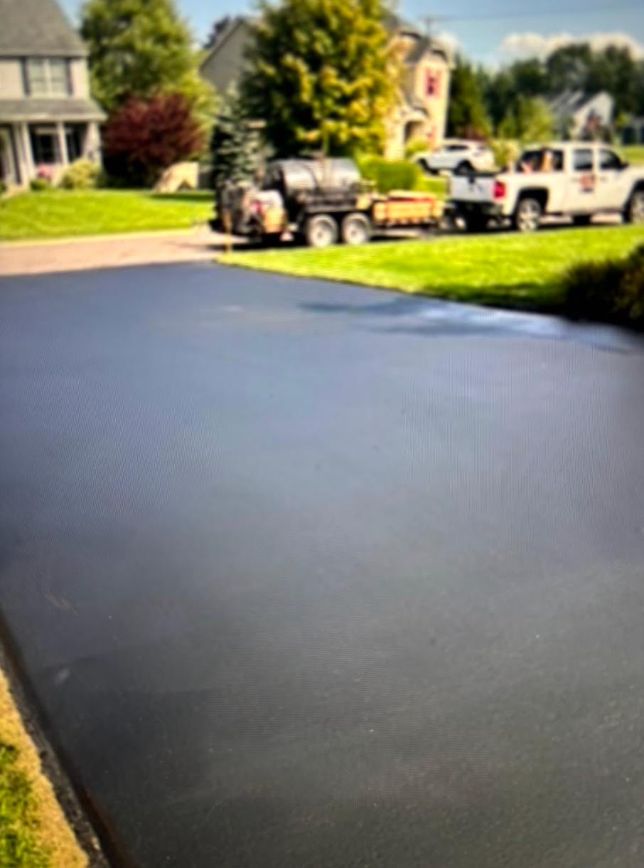 A jeep is parked in a driveway next to a house.