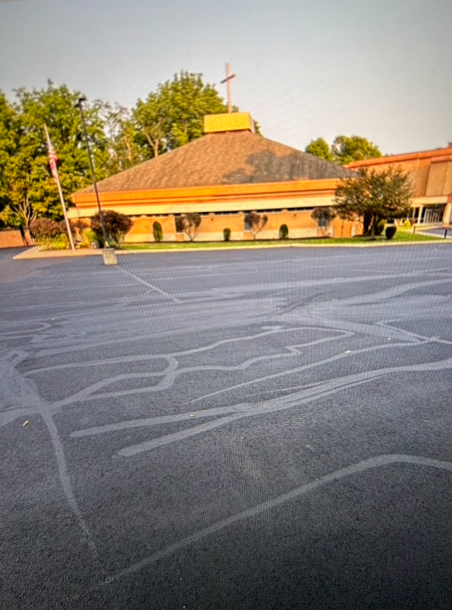 An empty parking lot with a church in the background