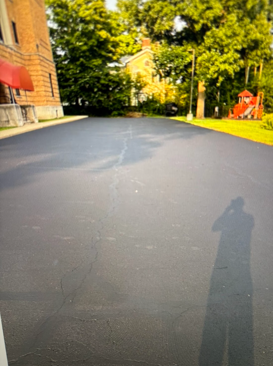 A person is taking a picture of their shadow on the road.