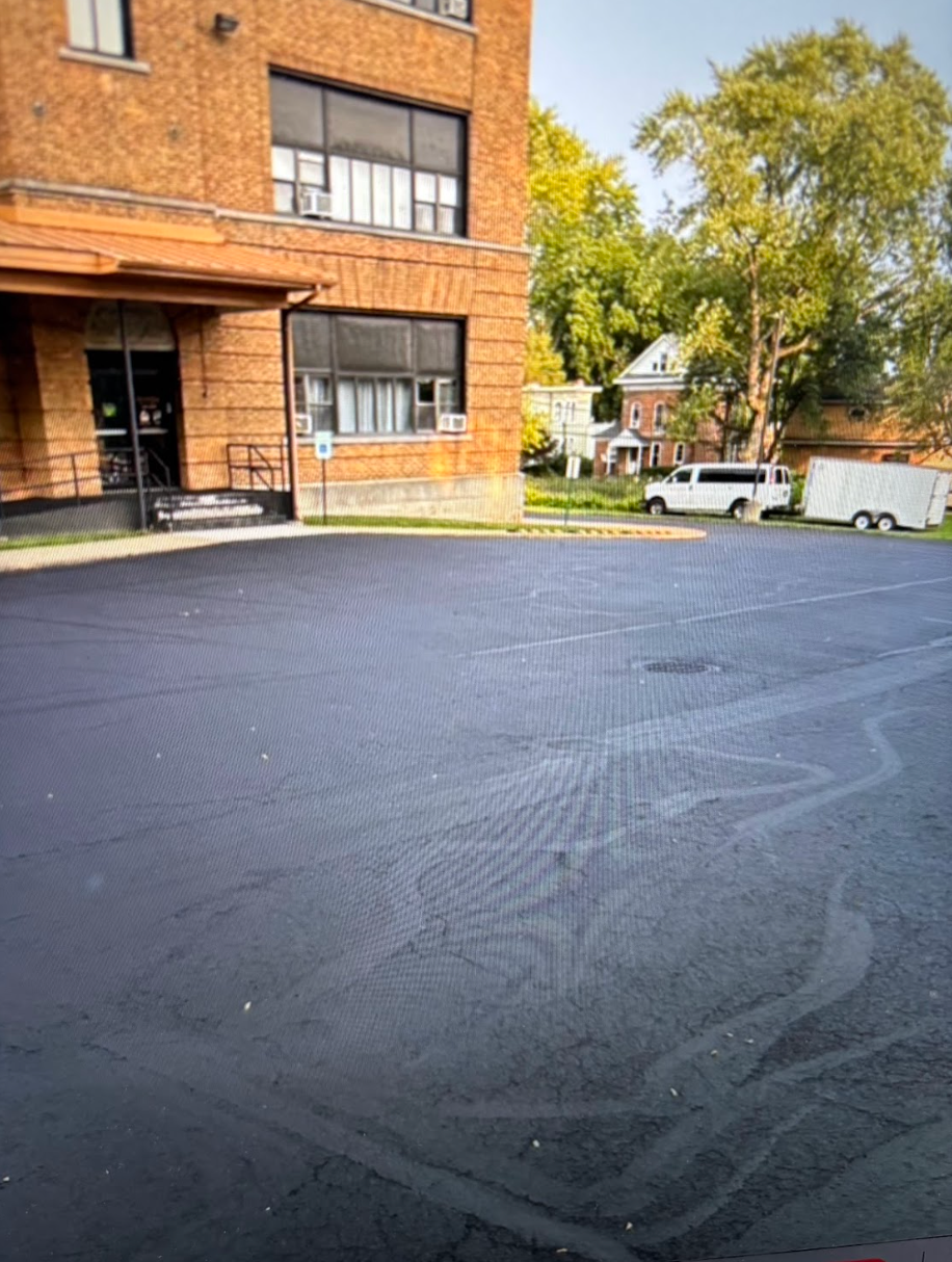 A parking lot with a brick building in the background