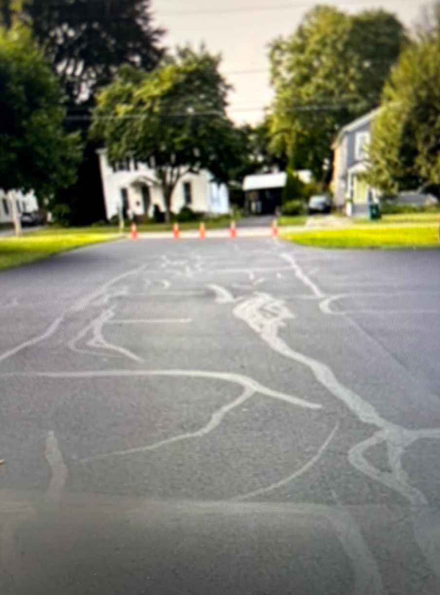 A parking lot with a house in the background