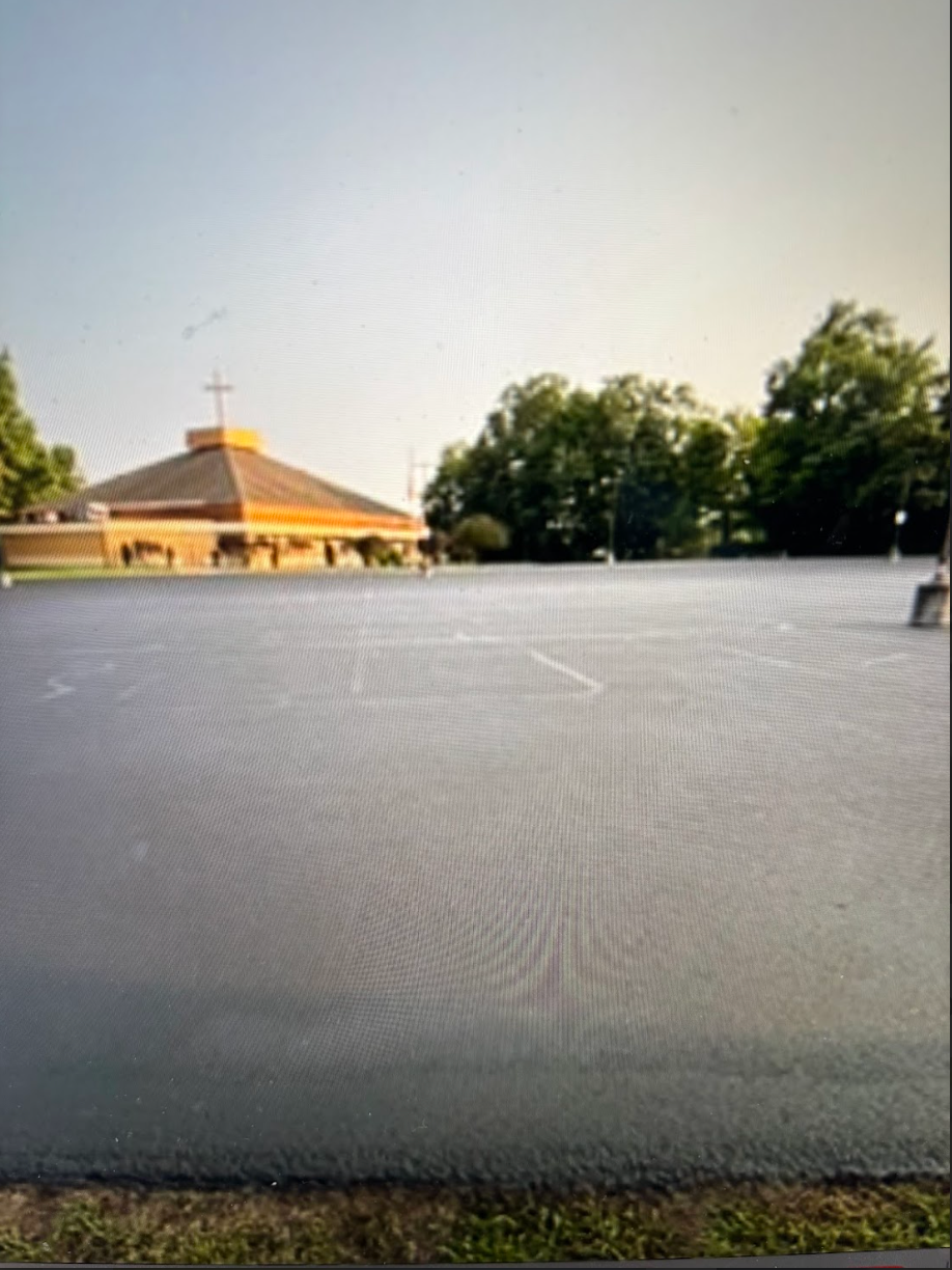 An empty parking lot with a church in the background
