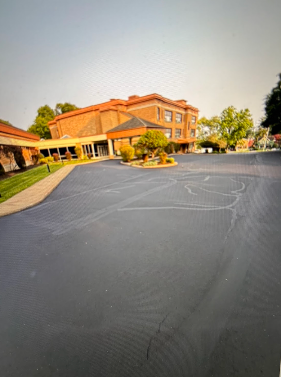 A parking lot with a brick building in the background