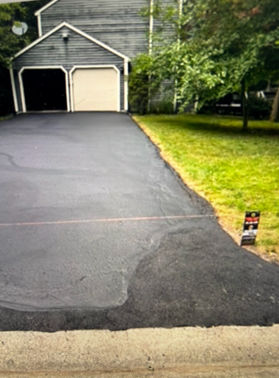 A driveway that has been paved in front of a house.