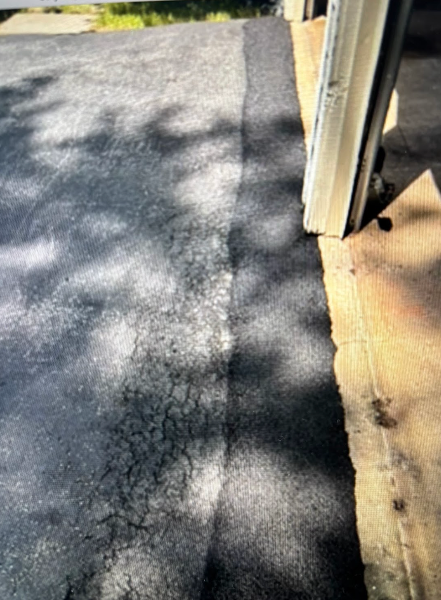 A close up of a driveway next to a garage door.