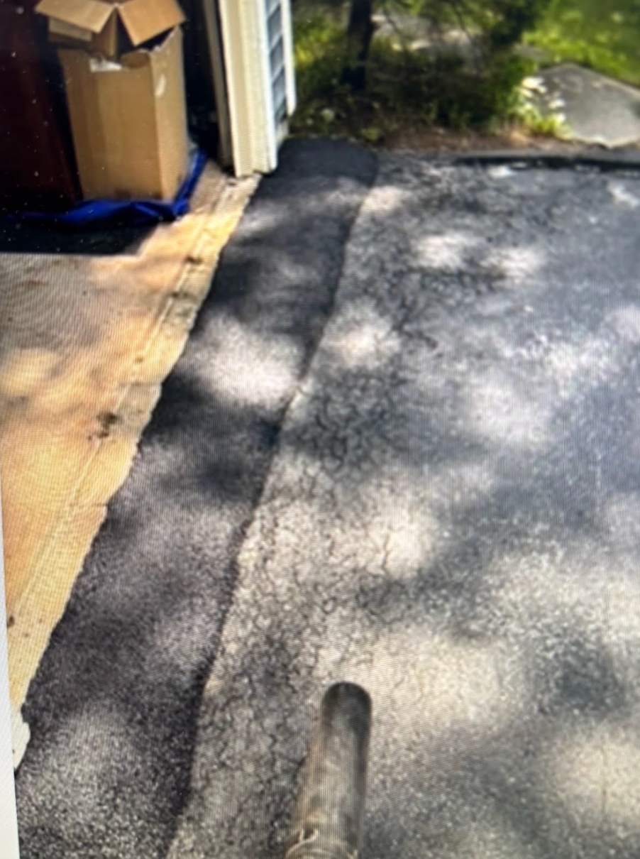 A person is standing on a sidewalk next to a garage.