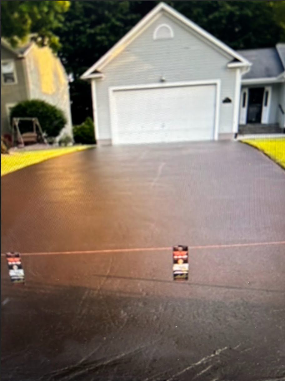 A concrete driveway in front of a white house