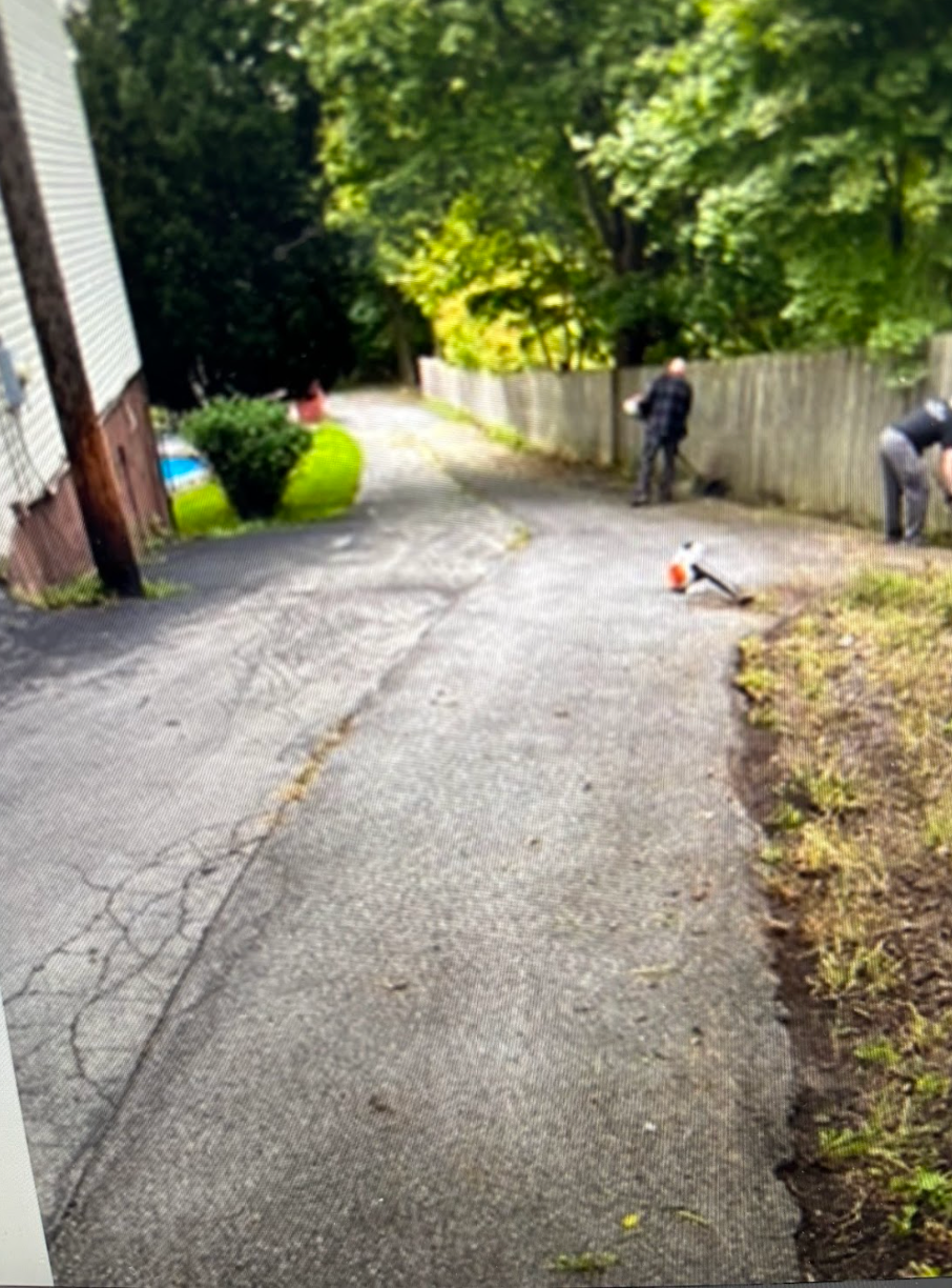 A group of people are standing on the side of a road.