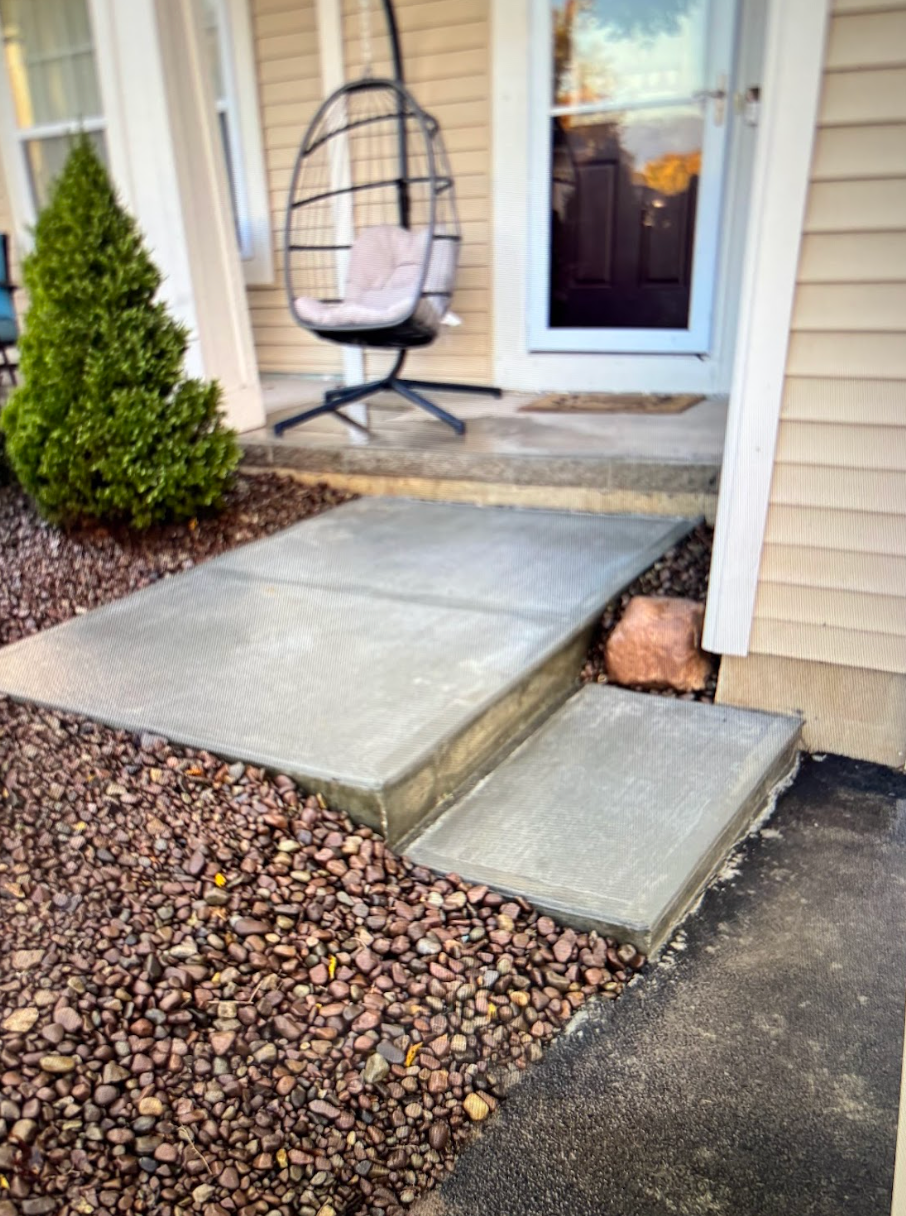 A concrete walkway leading to the front door of a house