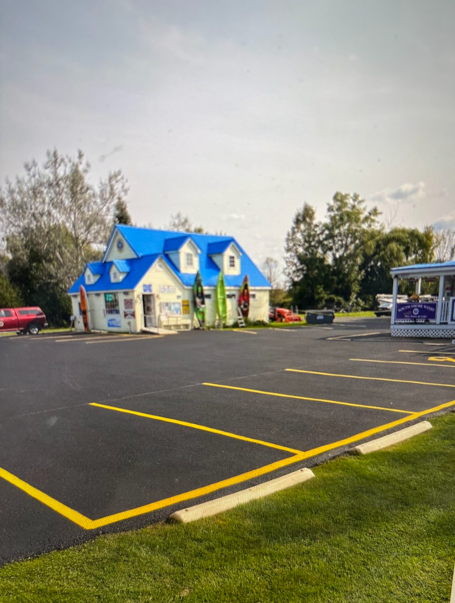 A blue and white house with a parking lot in front of it.